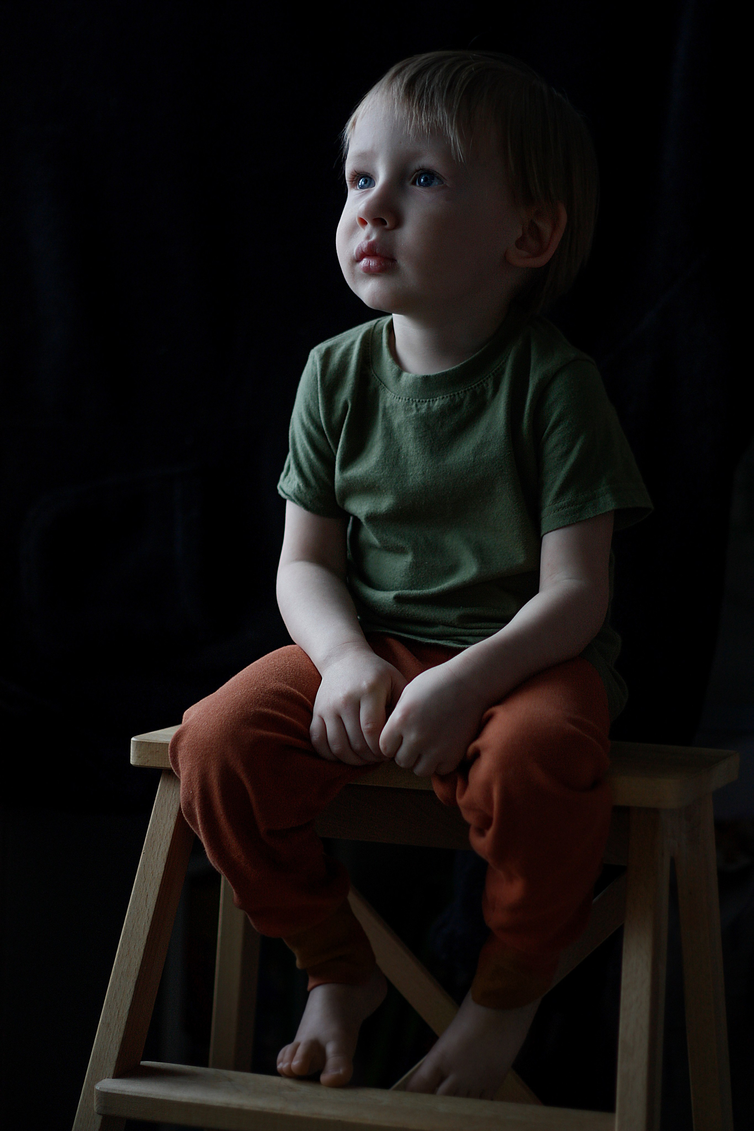 портрет ребенка мальчик сидит на стуле и смотрит вбок красиво падает свет