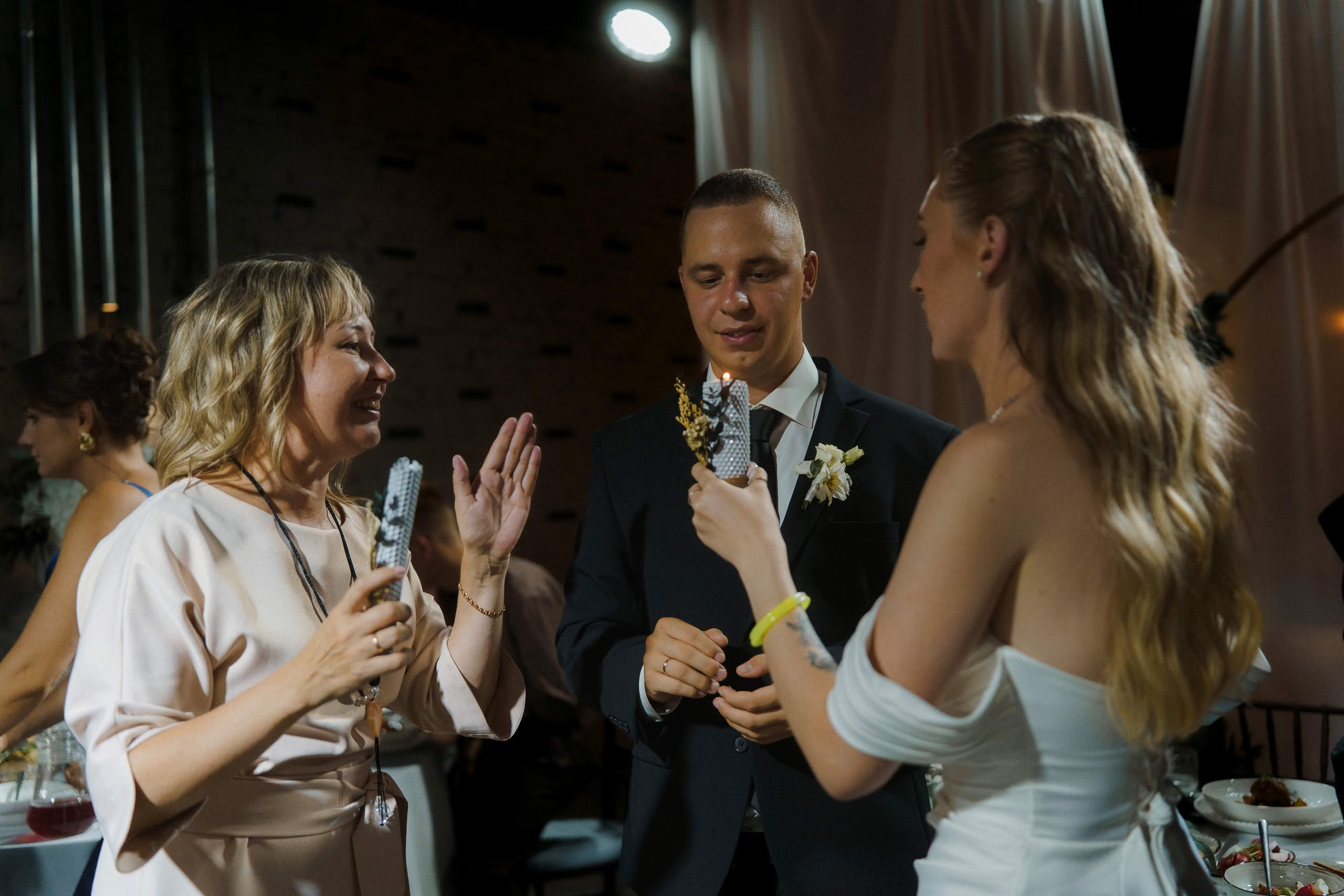 Молодожёны и гости со свечами на свадебном вечере в Петербурге