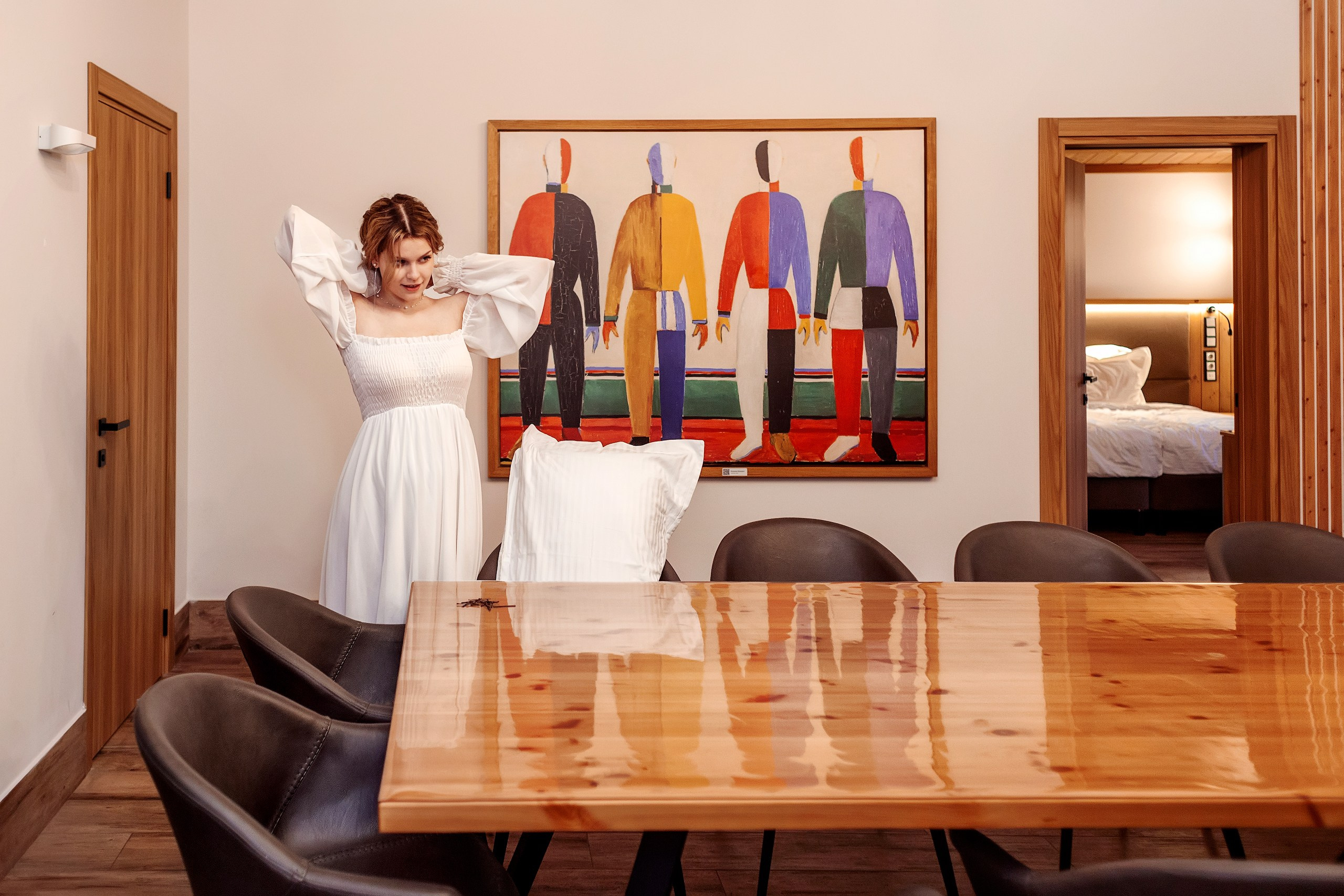 Девушка поправляет волосы у большого стола