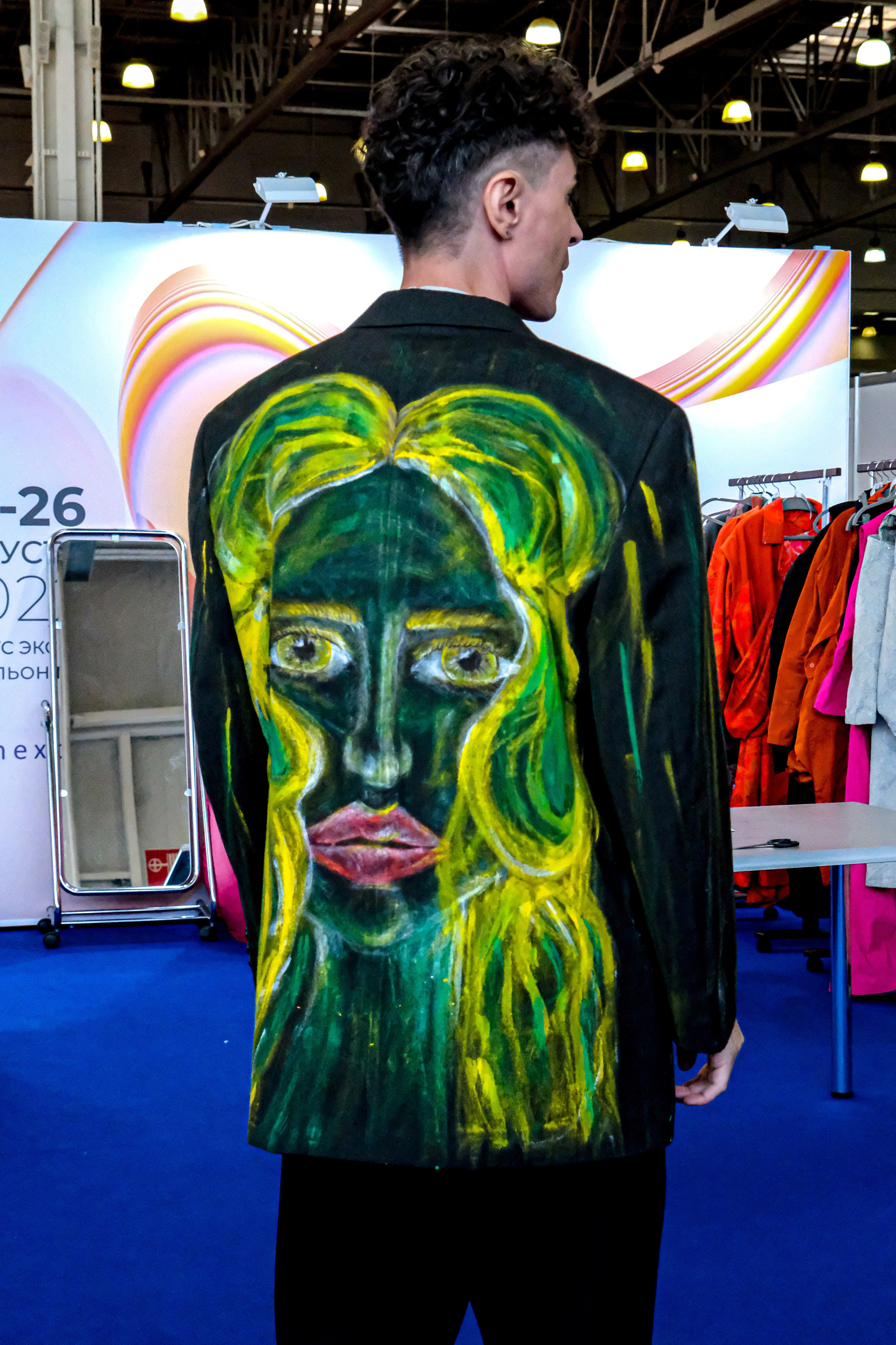  "Модели в ярких нарядах проходят по подиуму во время показа мод, освещенные яркими софитами и окруженные восторженными зрителями."