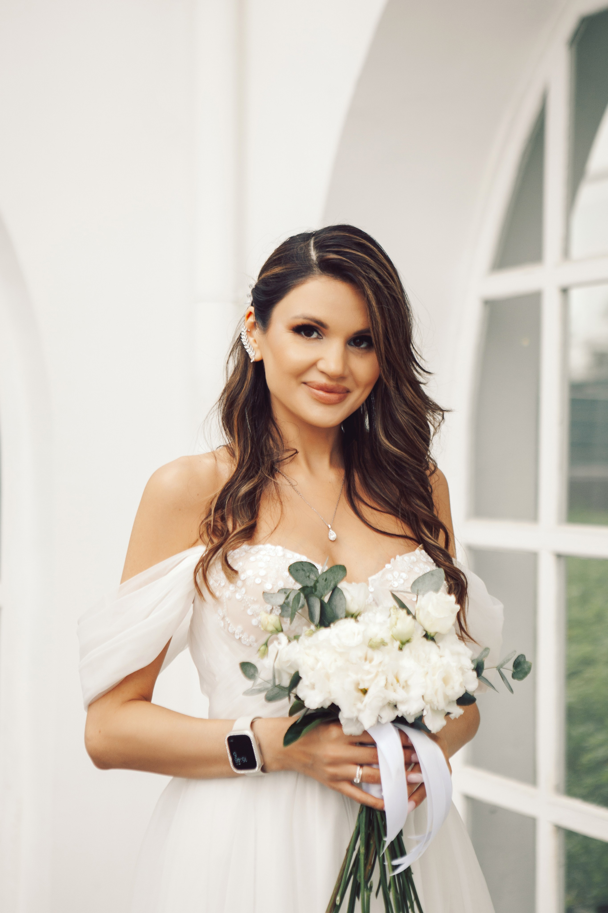 Фото стильной невесты в длинном платье и с букетом на вднх у ресторана