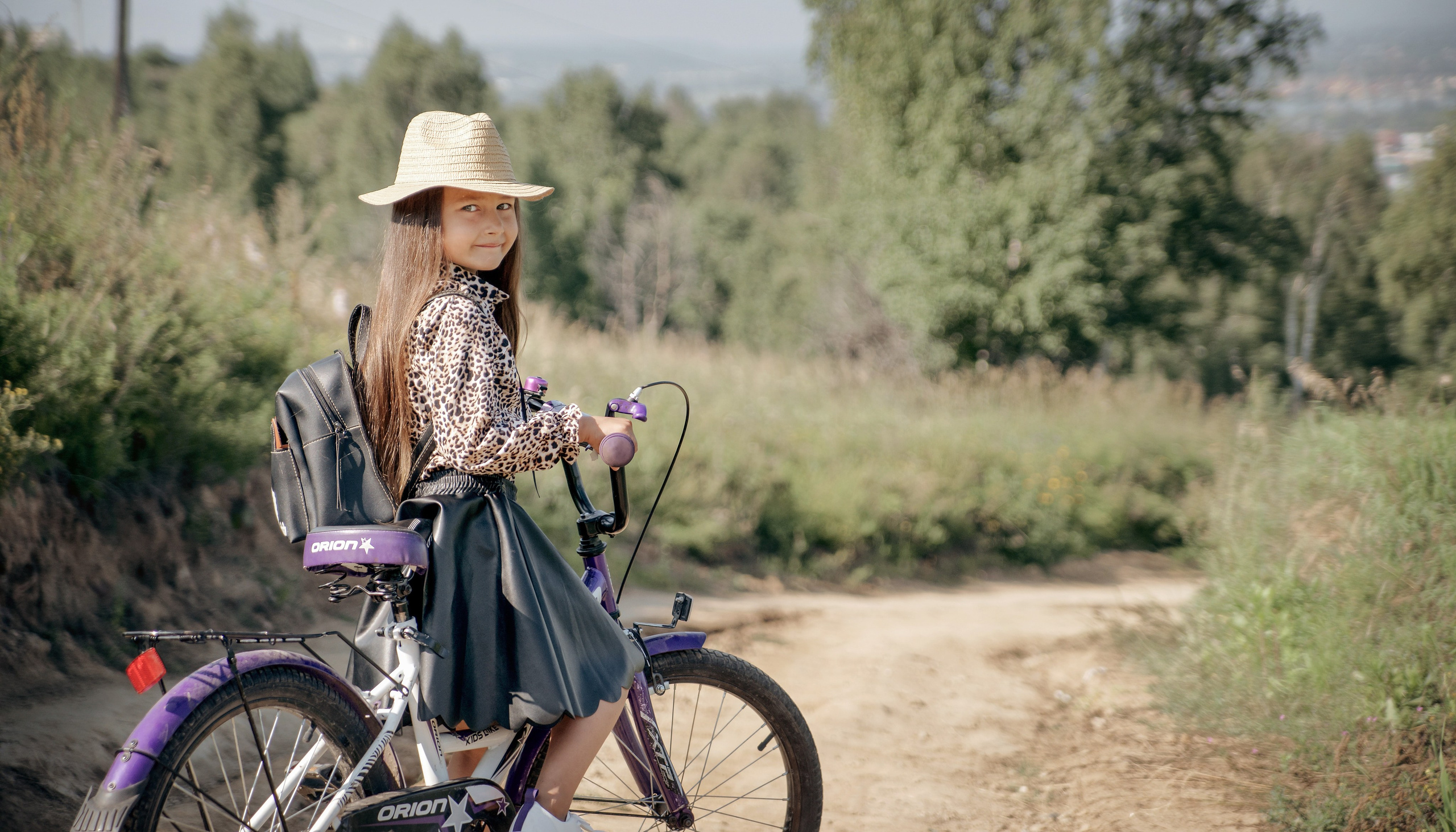 Детская фотосессия летом - девочка стоит с велосипедом