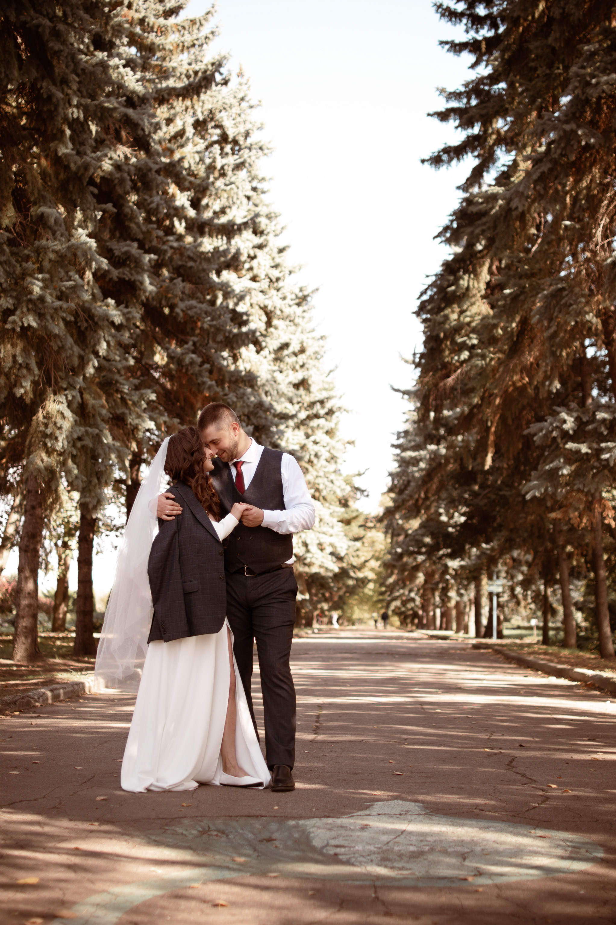 Пара молодоженов прогуливается по ботаническому саду.