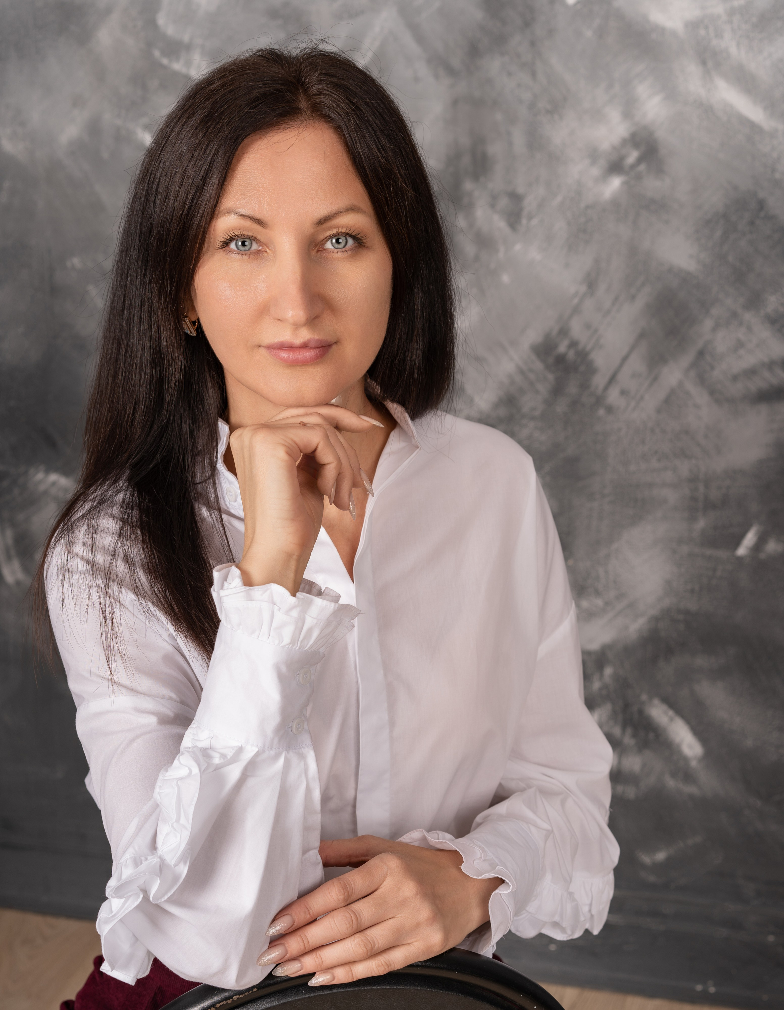 Женский портрет, нежный образ, естественное освещение, студийная съёмка, мягкий женский образ, крупные глаза, улыбка, натуральный макияж, элегантная причёска, белый фон, 