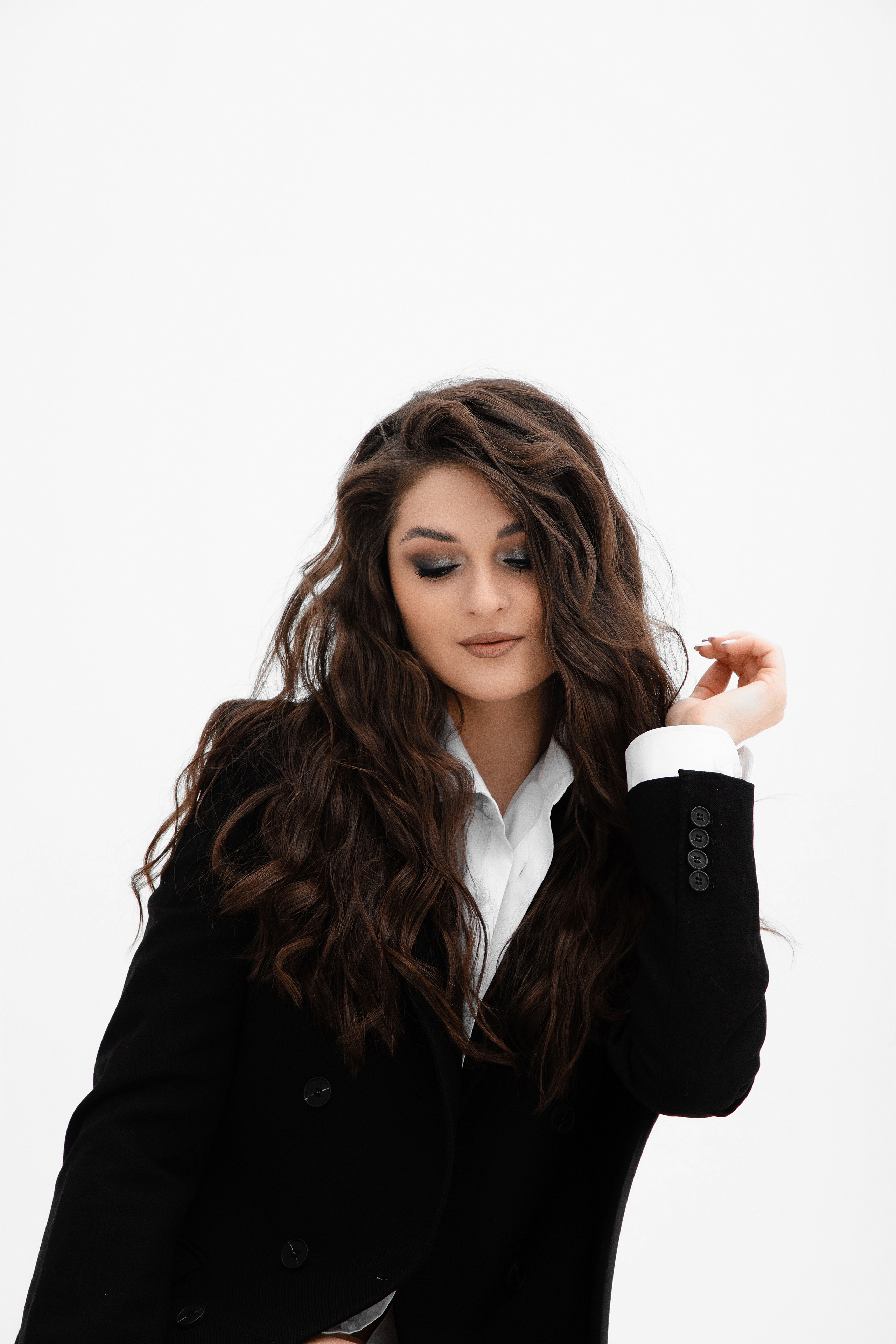 Портрет девушки в мужской рубашке и пиджаке на белом фоне циклорамы