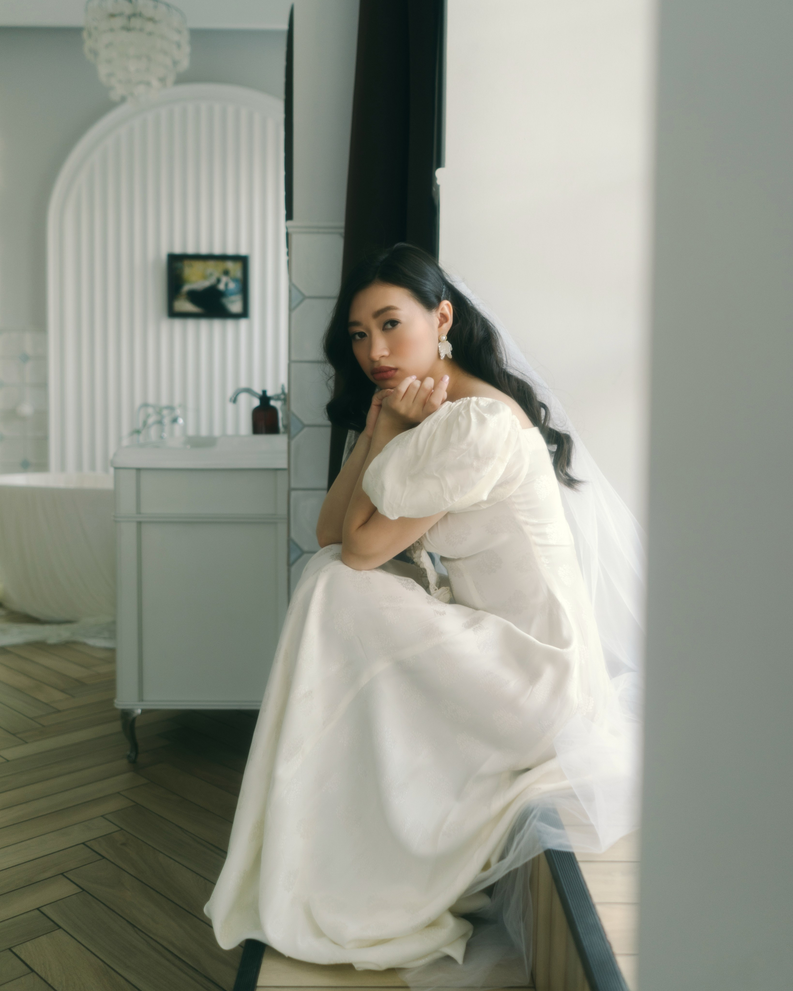 Невеста сидит в светлом интерьере, авторская свадебная фотосессия утра невесты в киноэстетике в СПб