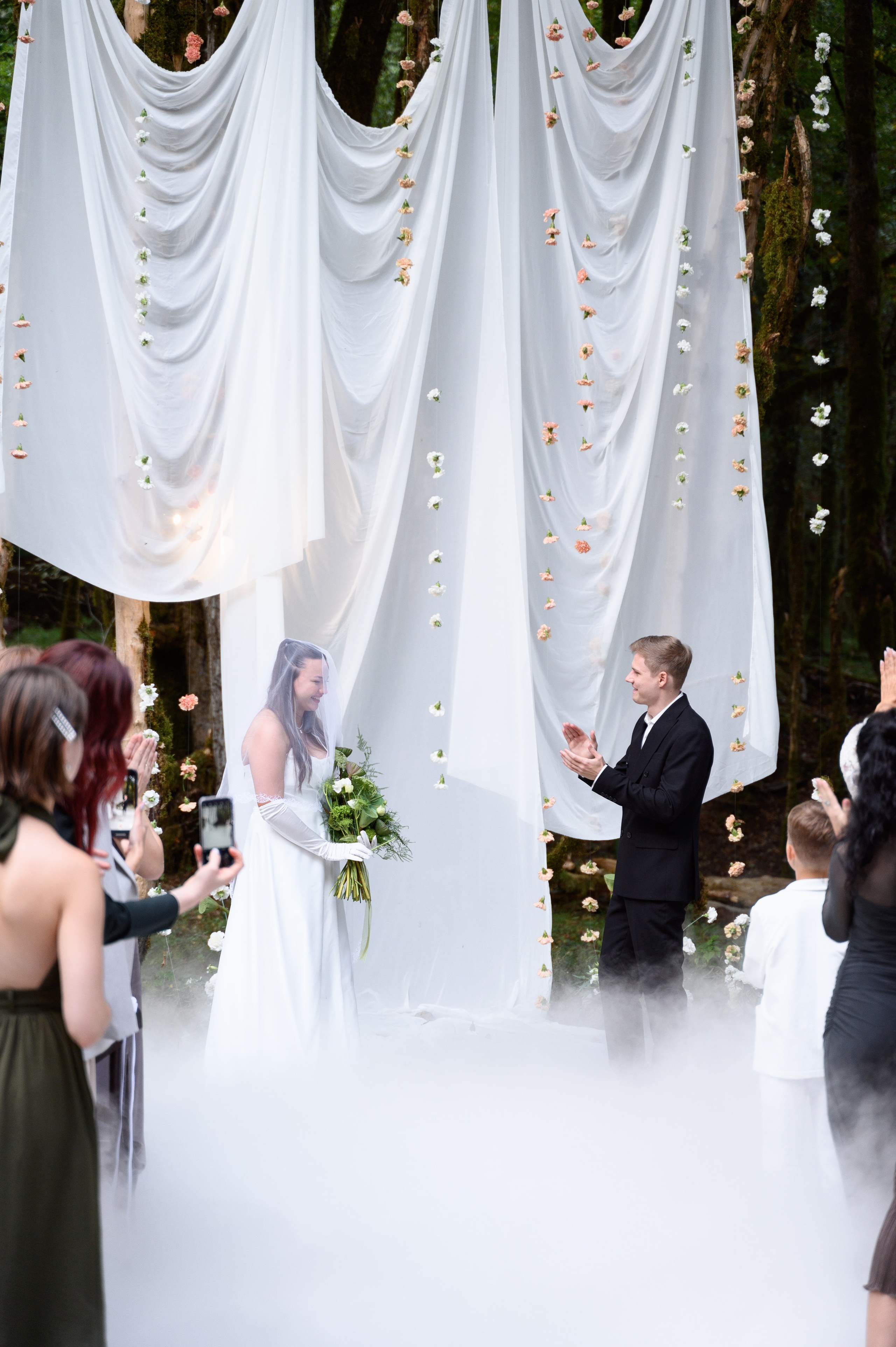 Фотосессия на фоне лесных пейзажей глэмпинга Енот, Сочи, для создания уникальных свадебных снимков с природой жених и невеста стоят и смотрят друг на  друга