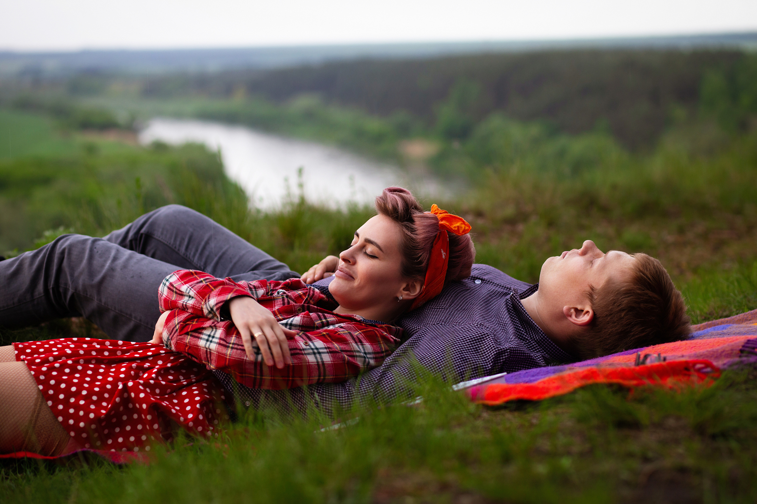 девушка в  красной  ретро одежде валяется на  траве рядом  с парнем на  берегу реки Кривоборье