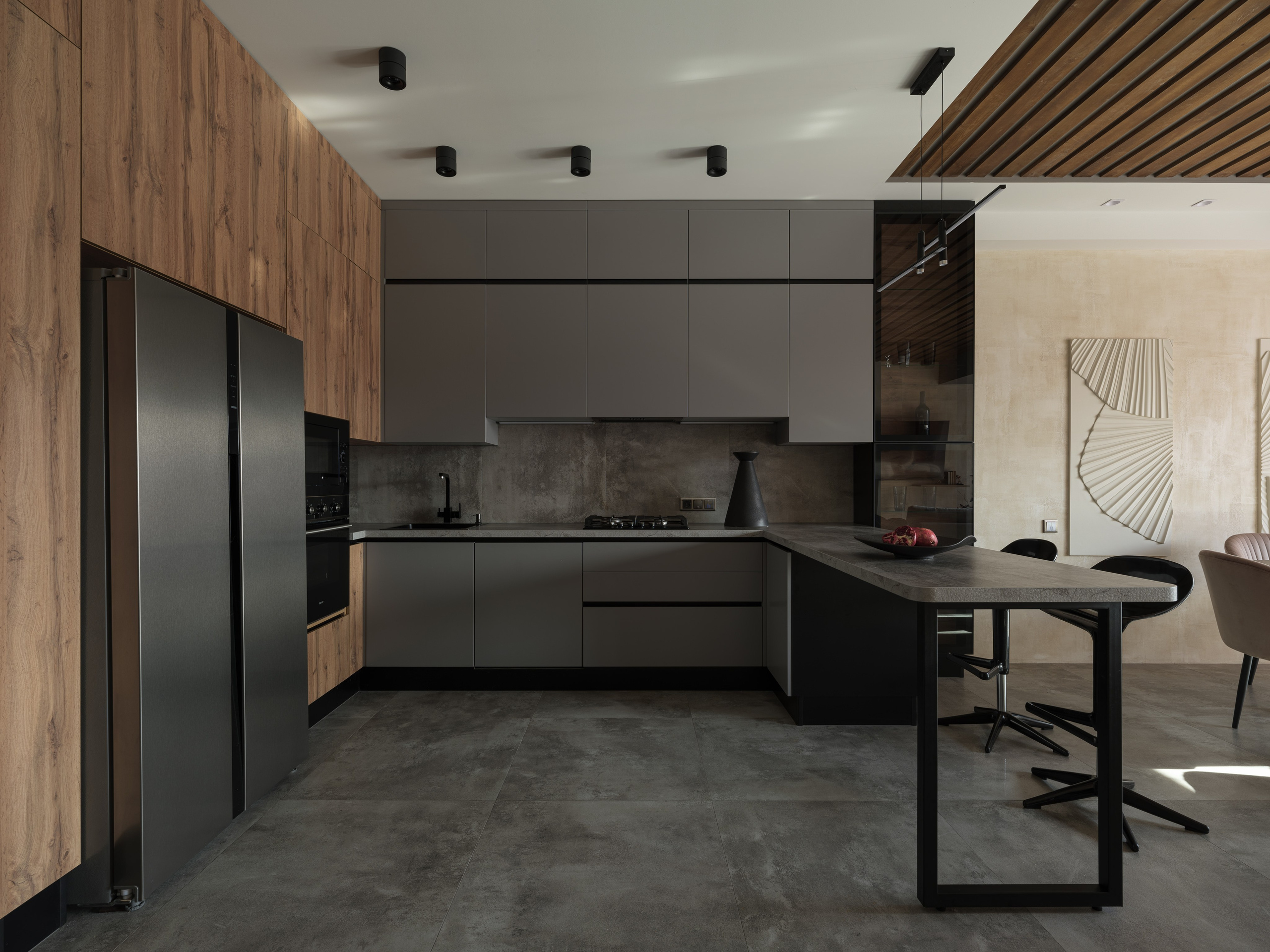 Современная кухня с серыми фасадами, барной стойкой и акцентной стеной под бетон. Лаконичность форм и игра света — дизайнер Алина Дёрова, стилист Наталья Якушева, фотограф Сергей Денисенко создали образ функциональной эстетики.