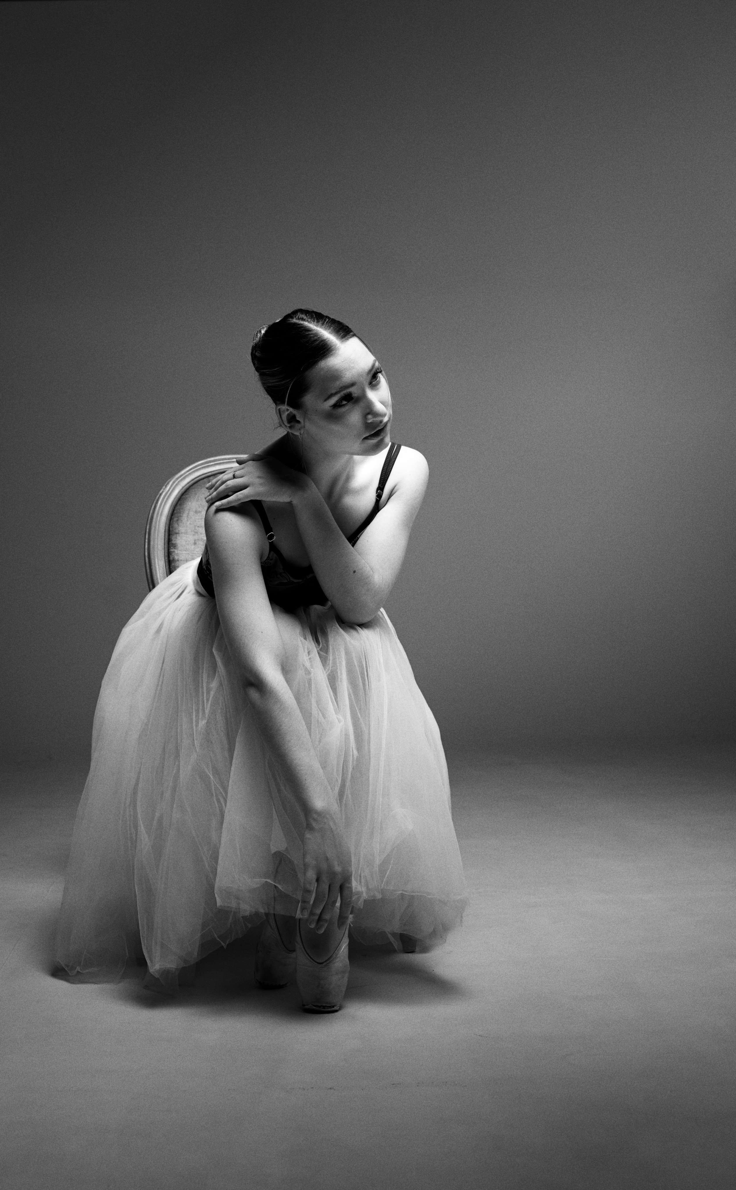 Черно-белый портрет балерины в юбке-шопенке, мягкий свет и акцент на фактуре ткани. Концепция тишины, легкости и классической эстетики в жанре спорт-арт.