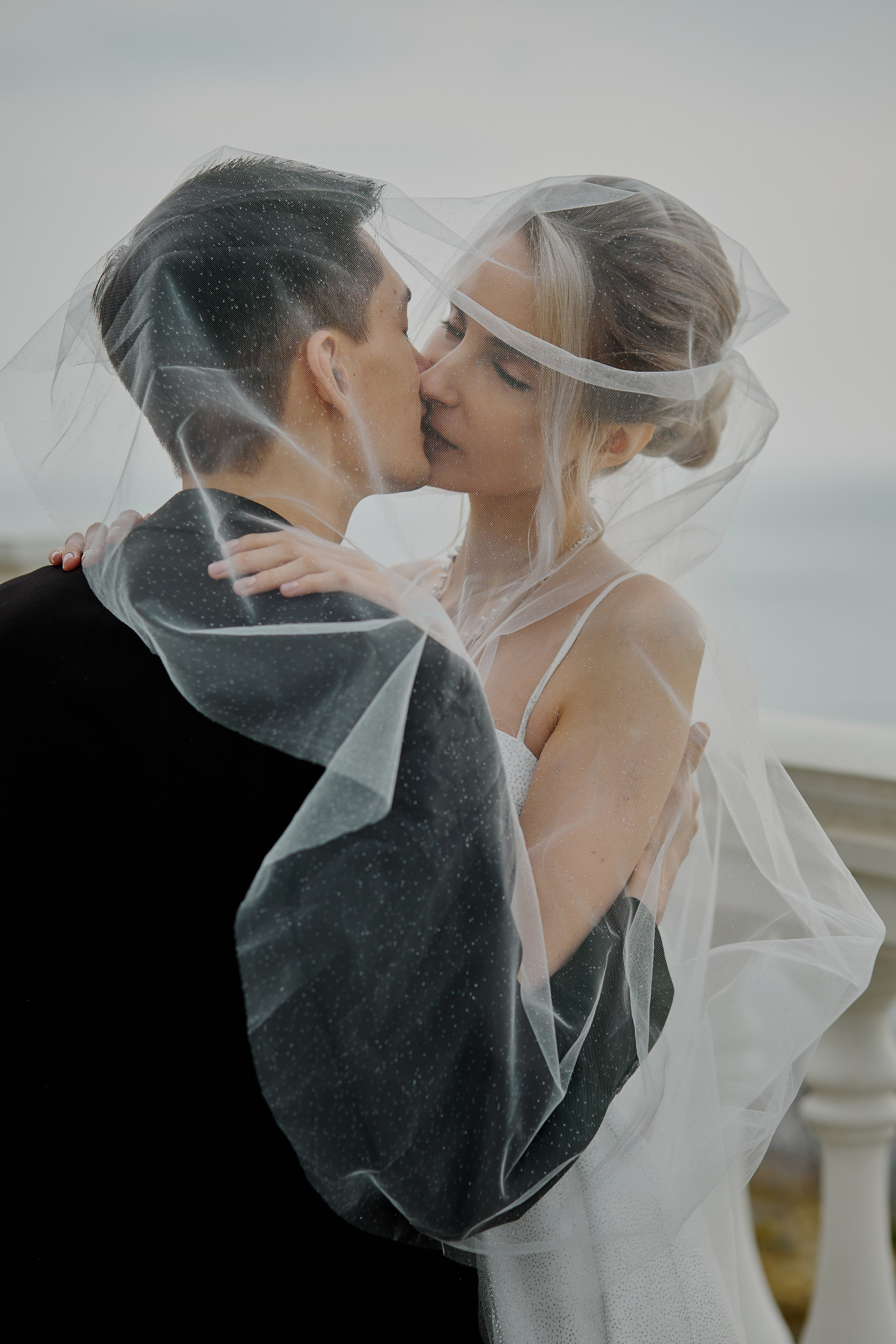 Поцелуй жениха и невесты под фатой, свадебная фотосессия в Анапе на белой набережной