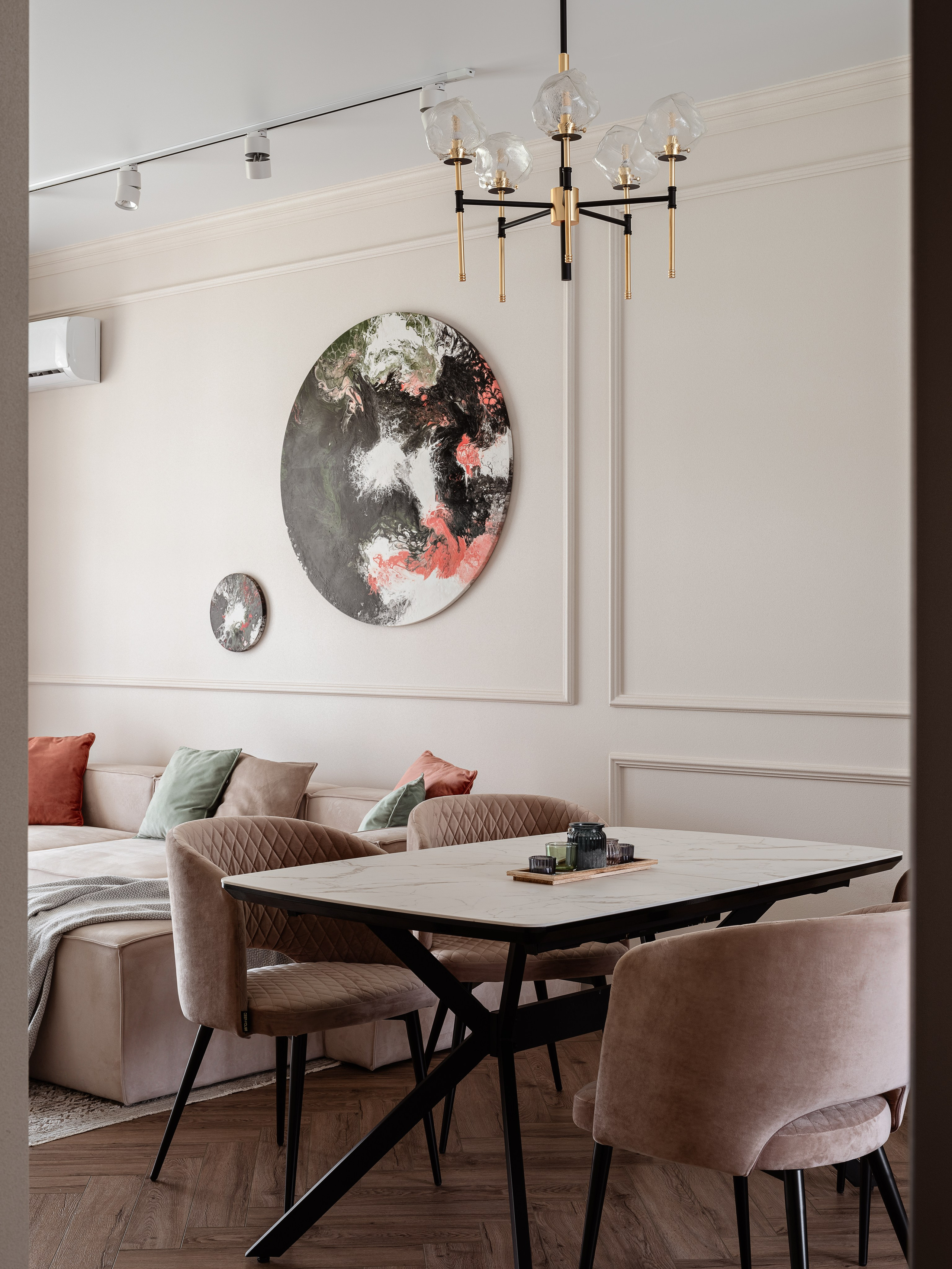 Столовая зона с мраморным столом, мягкими креслами и диваном с яркими подушками, акцент на круглые абстрактные картины. Автор дизайна Алина Чередниченко, интерьер снят фотографом Сергеем Денисенко.