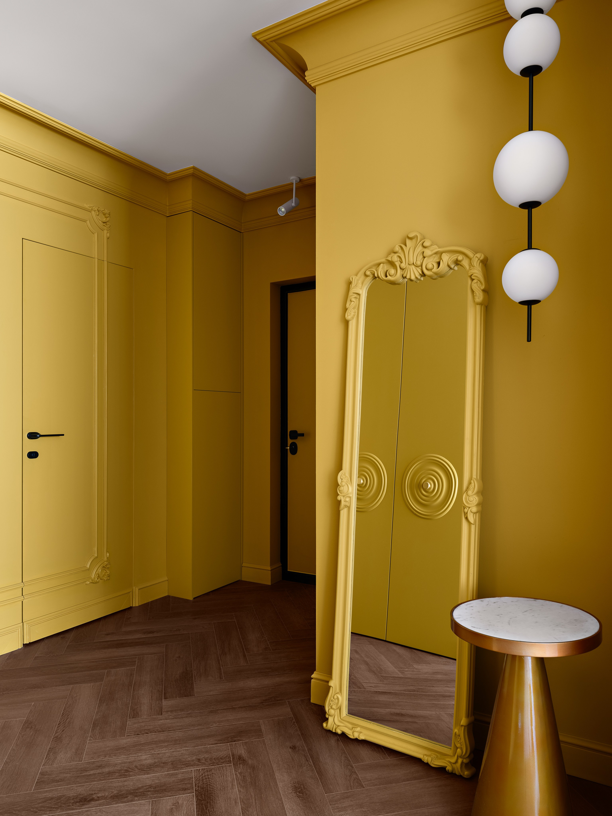 Эффектный интерьер коридора с насыщенными жёлтыми панелями, высоким зеркалом в резной раме и паркетным полом ёлочкой; уют и стиль в авторском проекте дизайнера Антона Логинова, стилизация Алёны Мощенской, фотограф Сергей Денисенко.