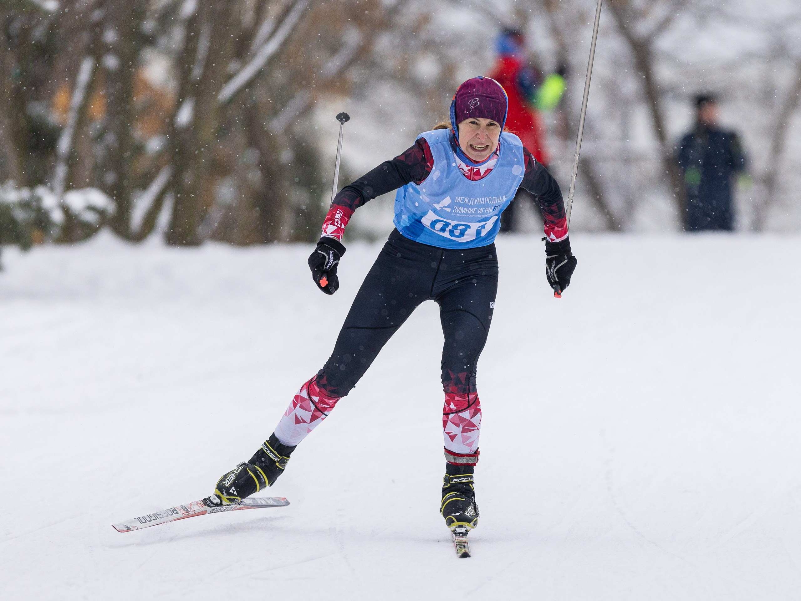 Лыжник применяет коньковый стиль на открытой заснеженной равнине.
