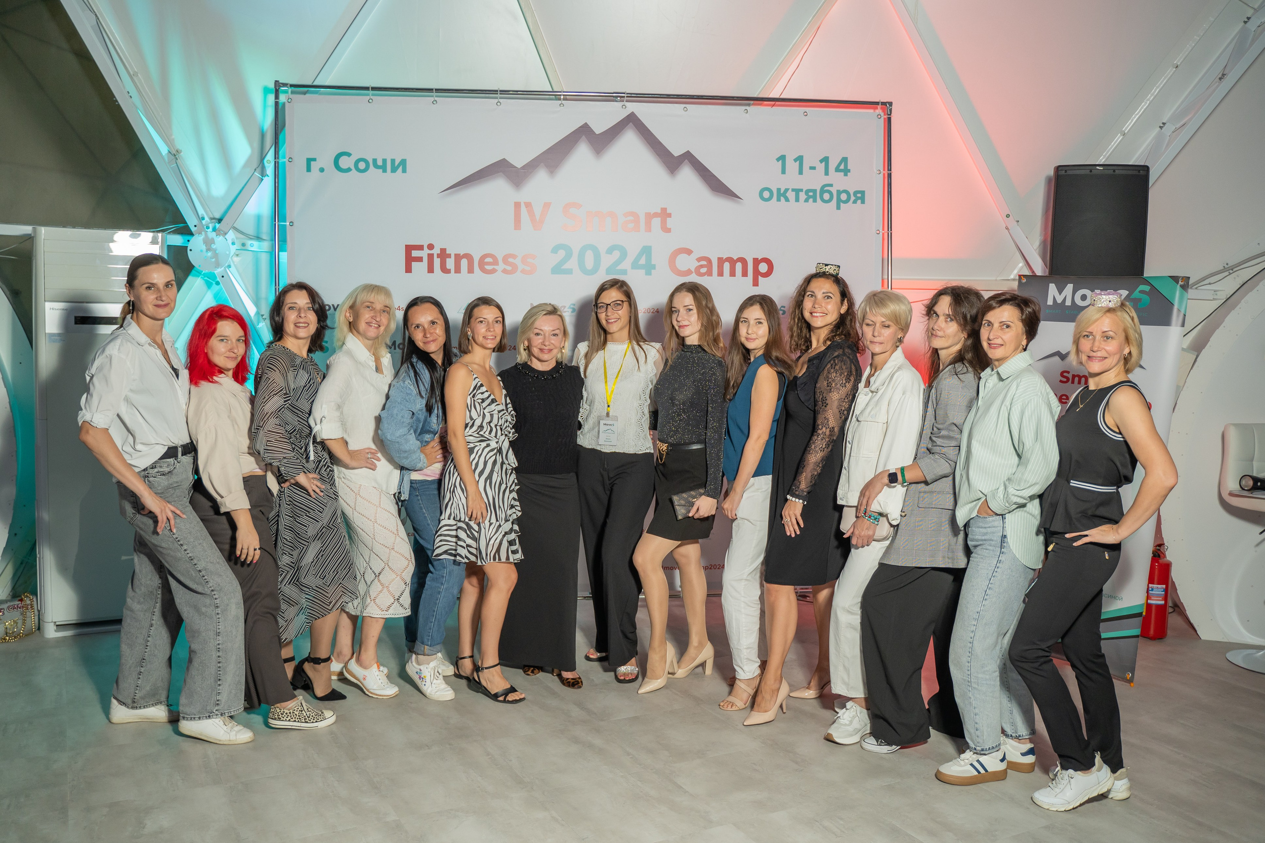 Общее фото участниц на фоне банера с мероприятия 