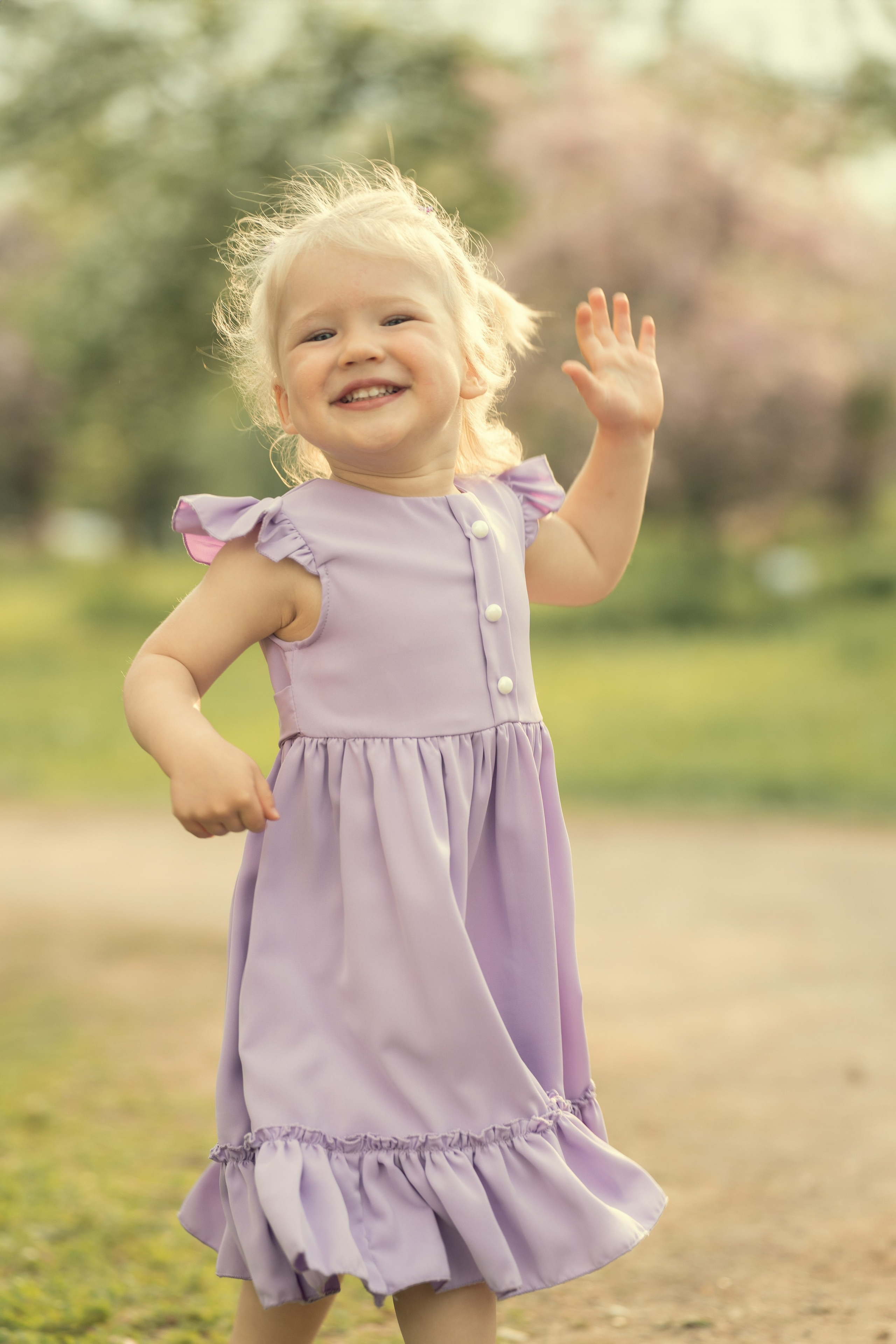 Ребенок задорно бежит по лужайке.