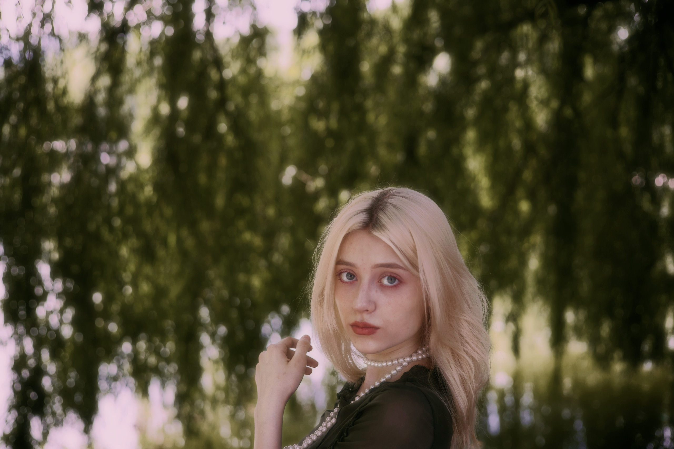 Портретный кадр с девушкой у перил на фоне зелёного парка