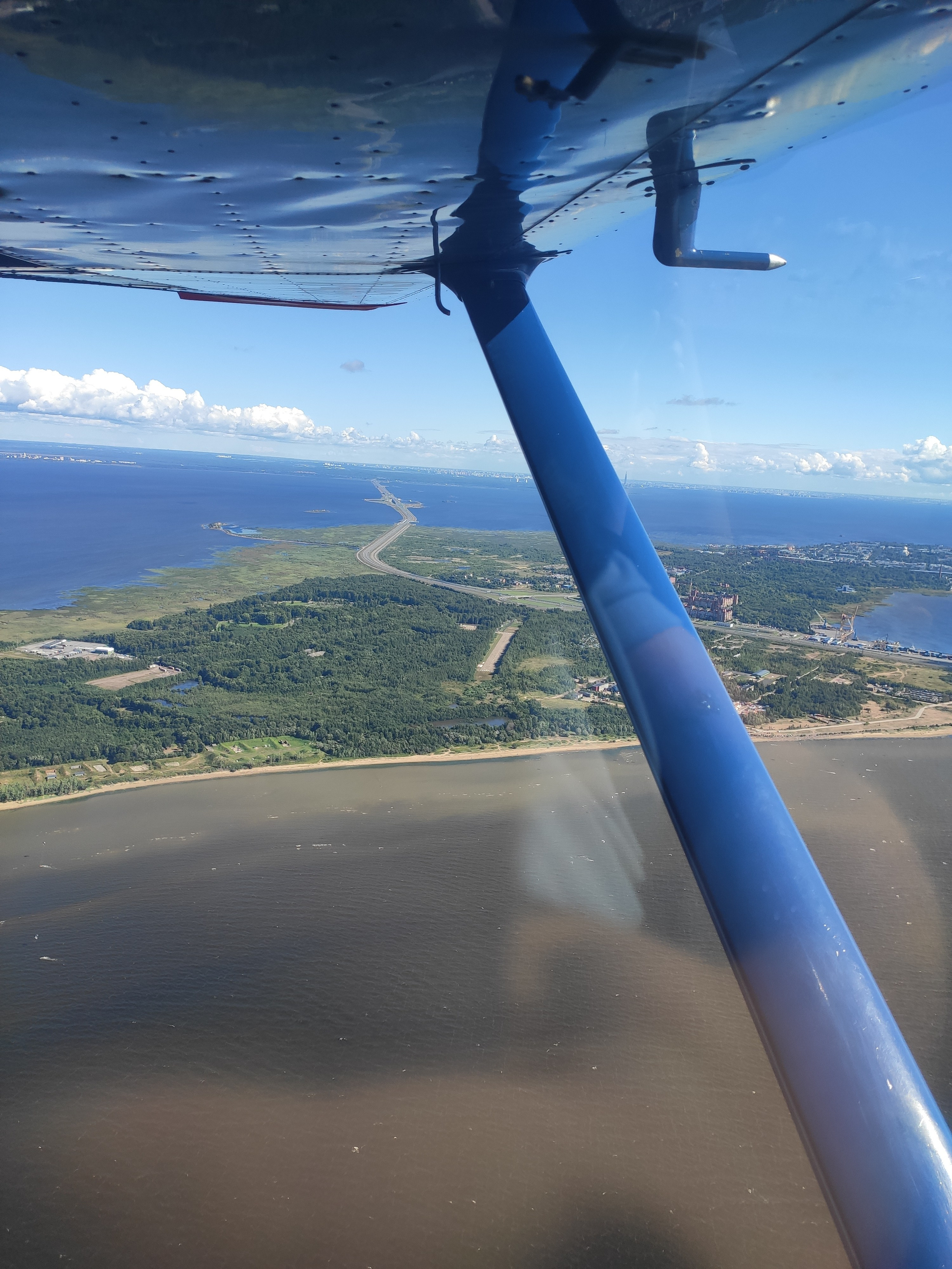 Под крылом видна полоса аэродрома "Бычье поле" и кусочек КАД на острове Котлин