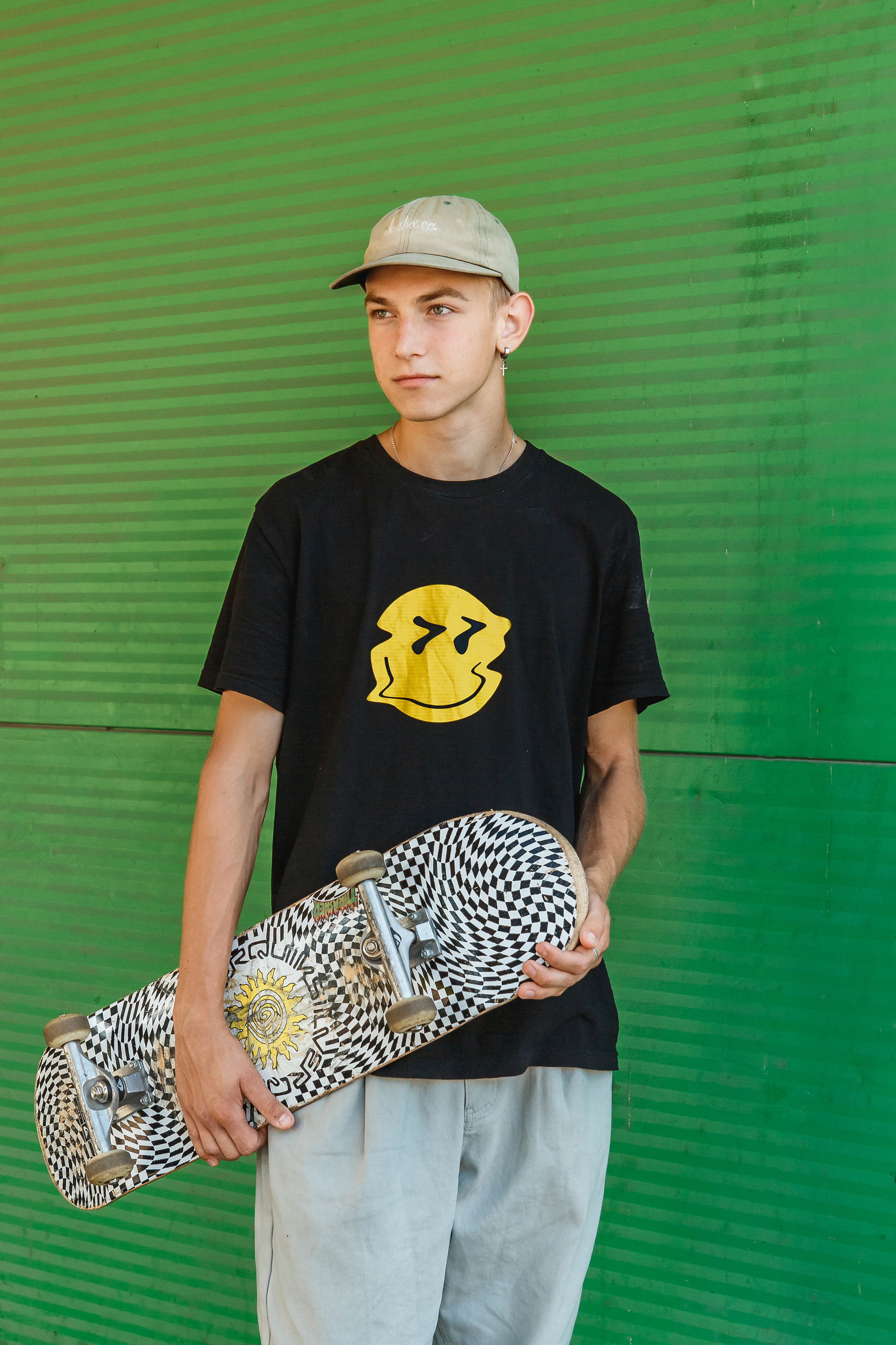 Спартивный и модный парень со скейтом в гараже