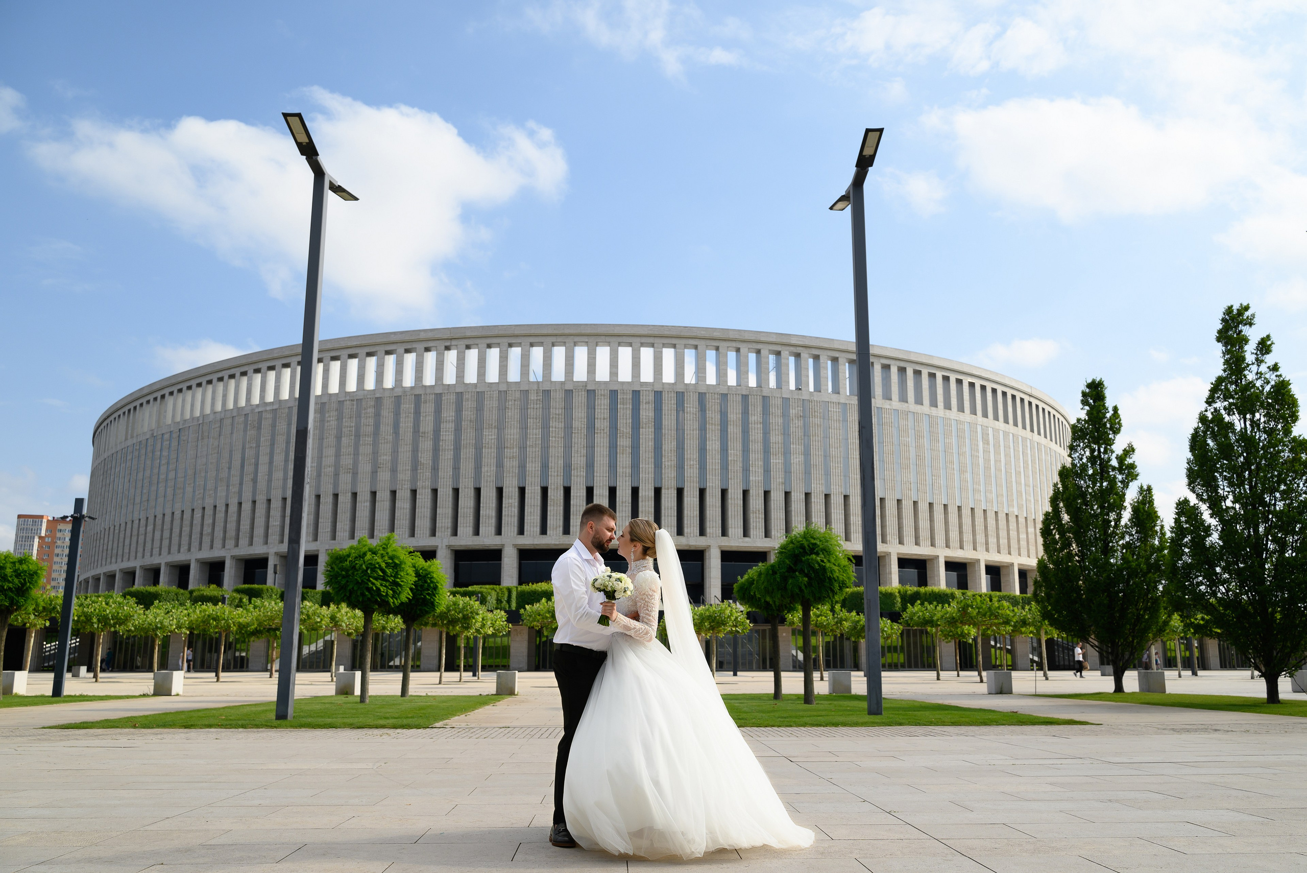 Свадебный фотограф запечатлил влюбленую пару на фоне стадиона Краснодар.
