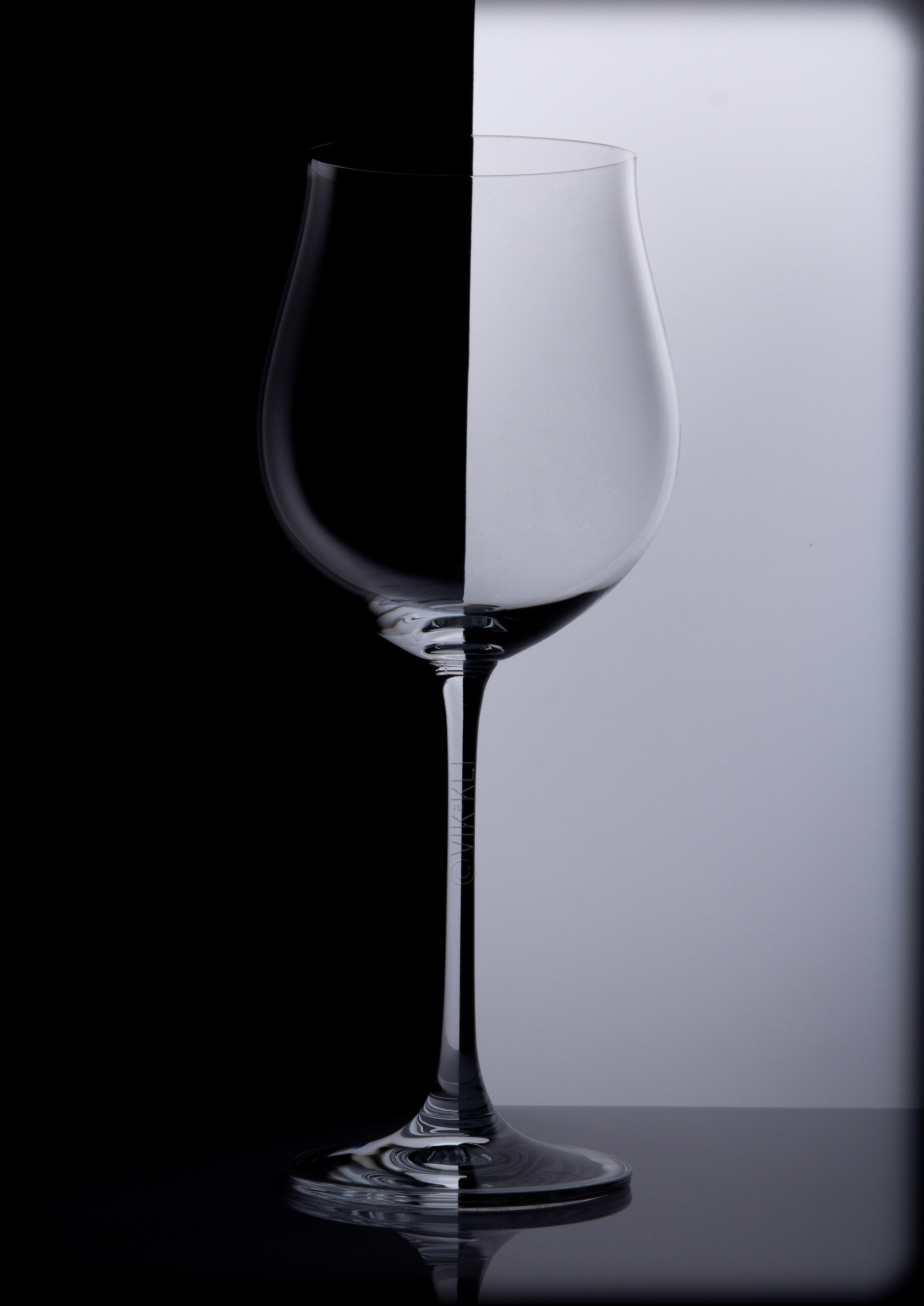 Стеклянный бокал на чёрно-белом фоне. Инь-янь. Предметное фото.