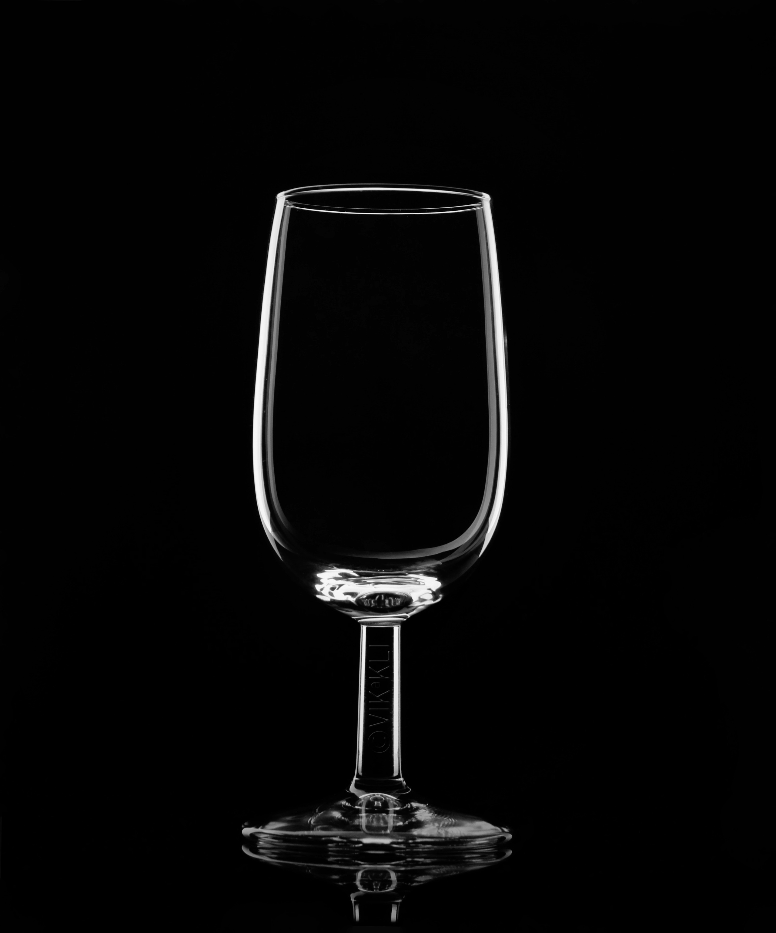 Стеклянный бокал на чёрном фоне. Предметное фото.