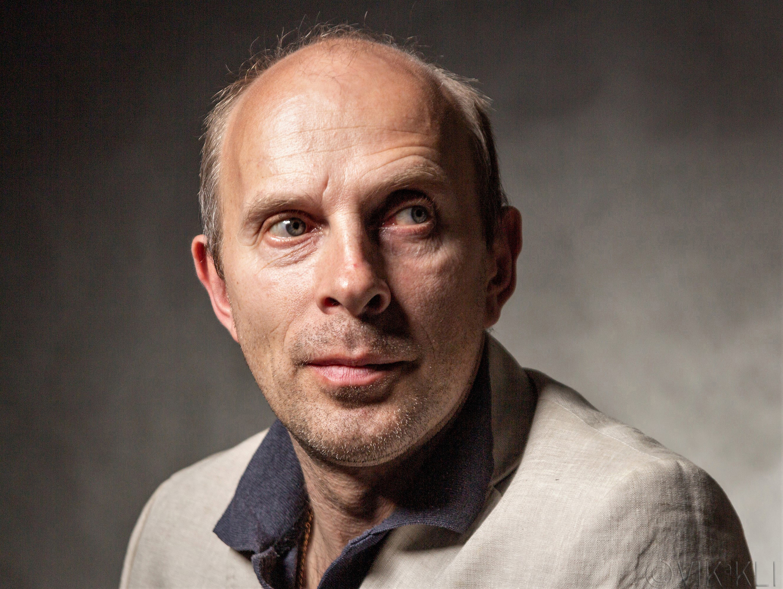 Портрет мужчины в белом пиджаке на чёрном фоне