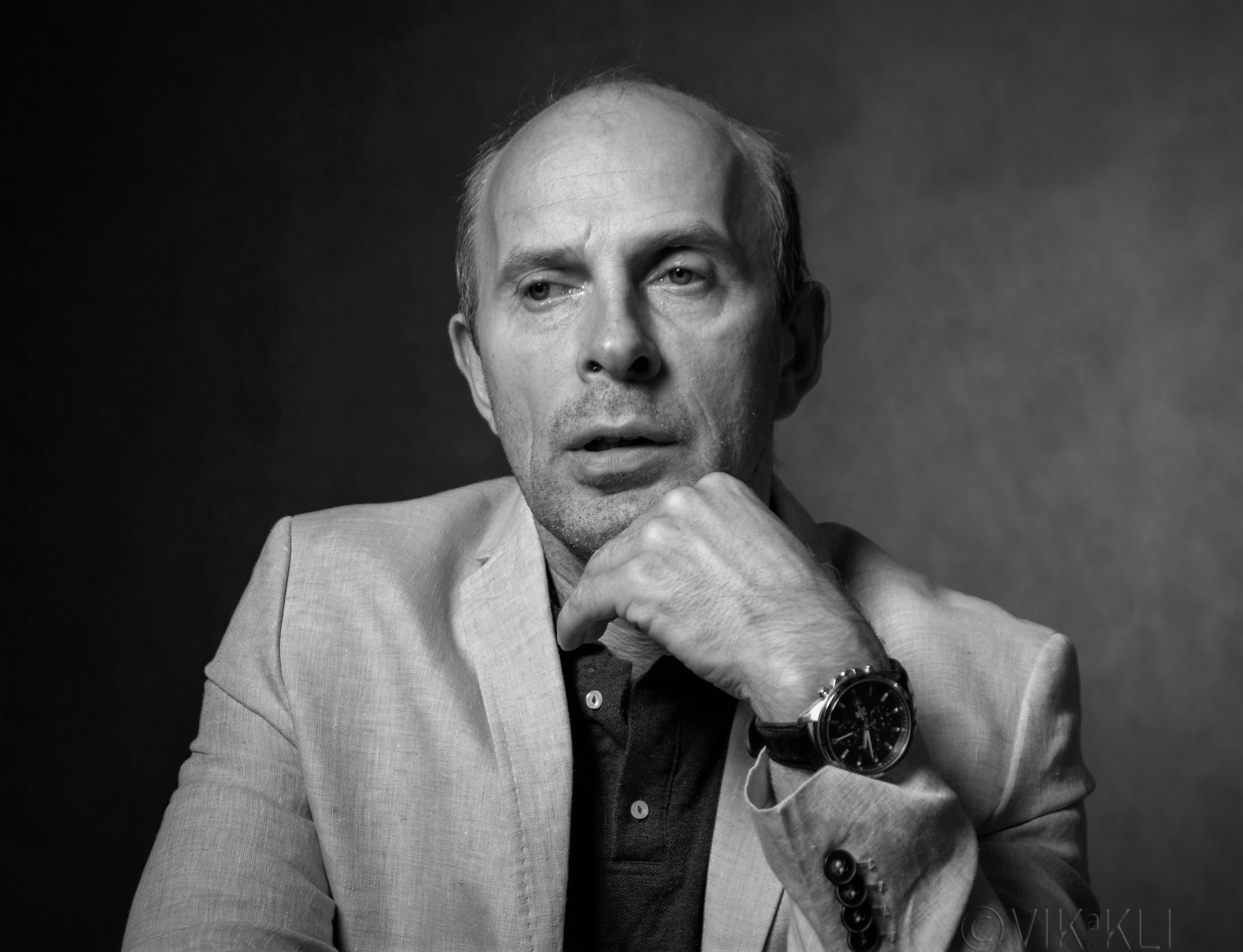 Чёрно-белый портрет мужчины в белом пиджаке на чёрном фоне