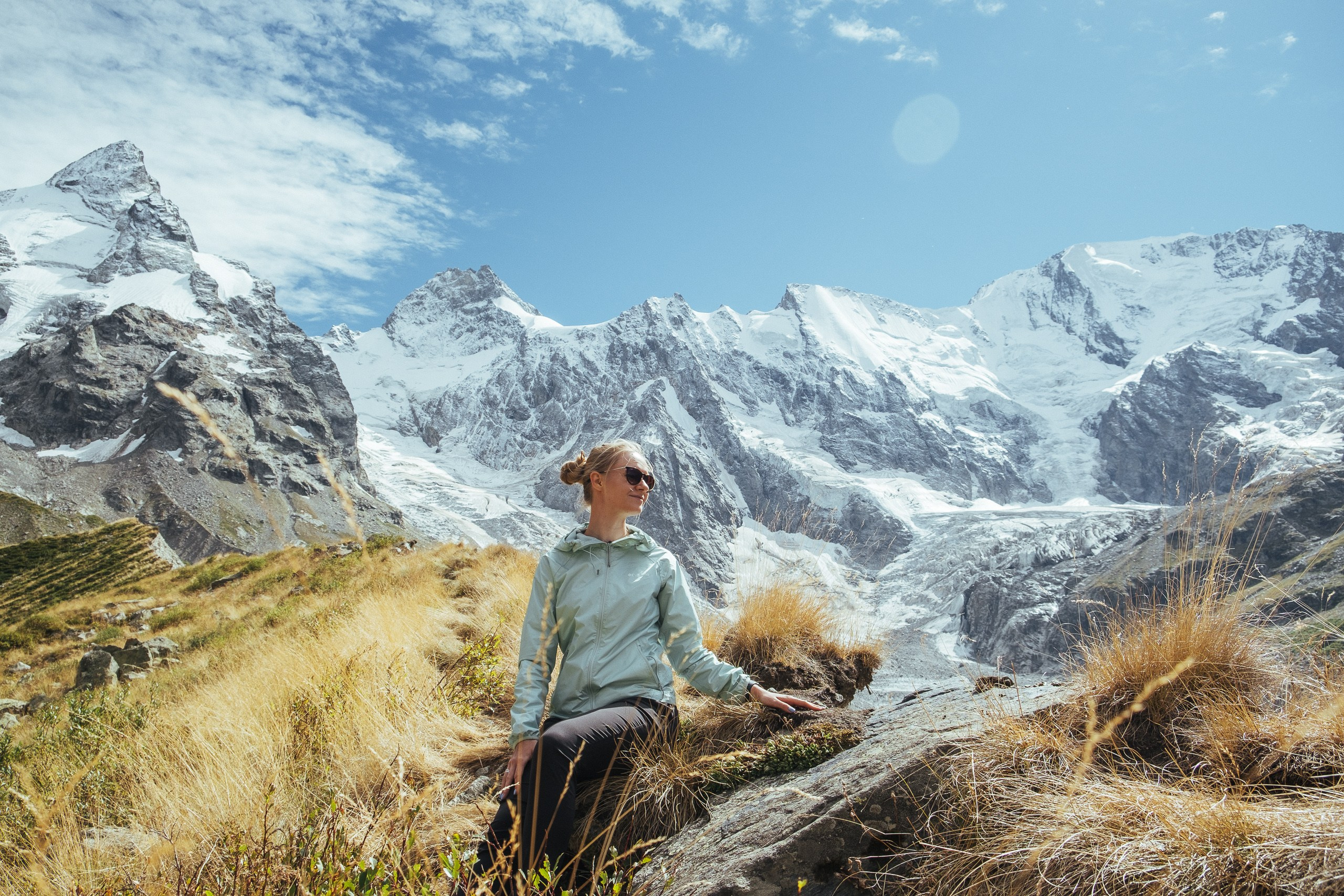 Турист в горной долине Приэльбрусья на фоне ледников и вершин Кавказа