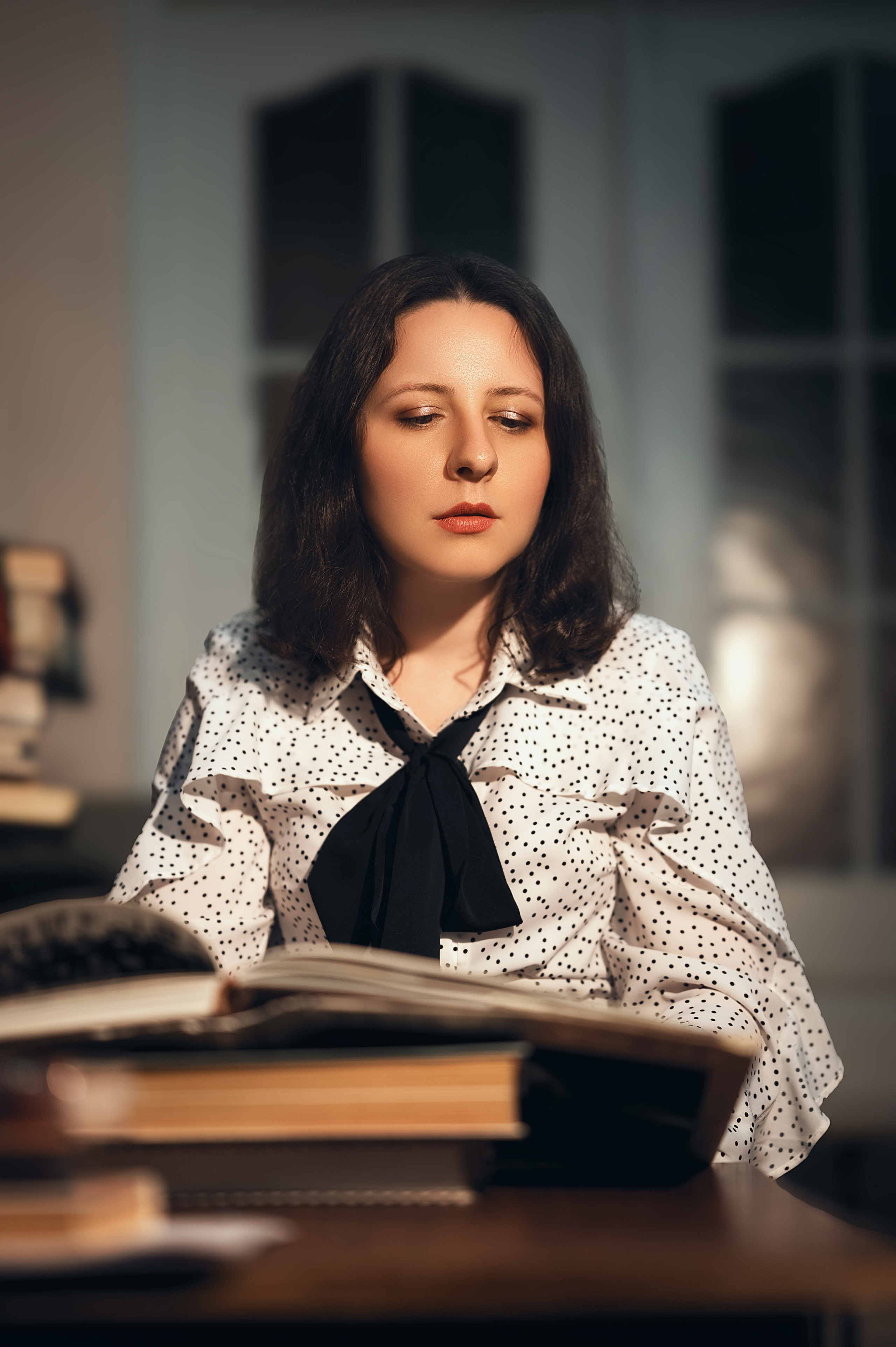 Фотосессия от Елизаветы Жуйковой: модель в библиотеке Волгодонска. Светлая блузка, тёмная юбка, книги, стеллажи — интеллектуальная атмосфера.