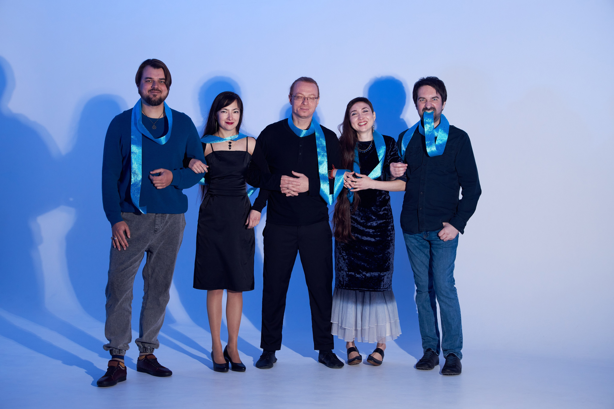 Групповое фото пяти человек с лентами и цветным светом