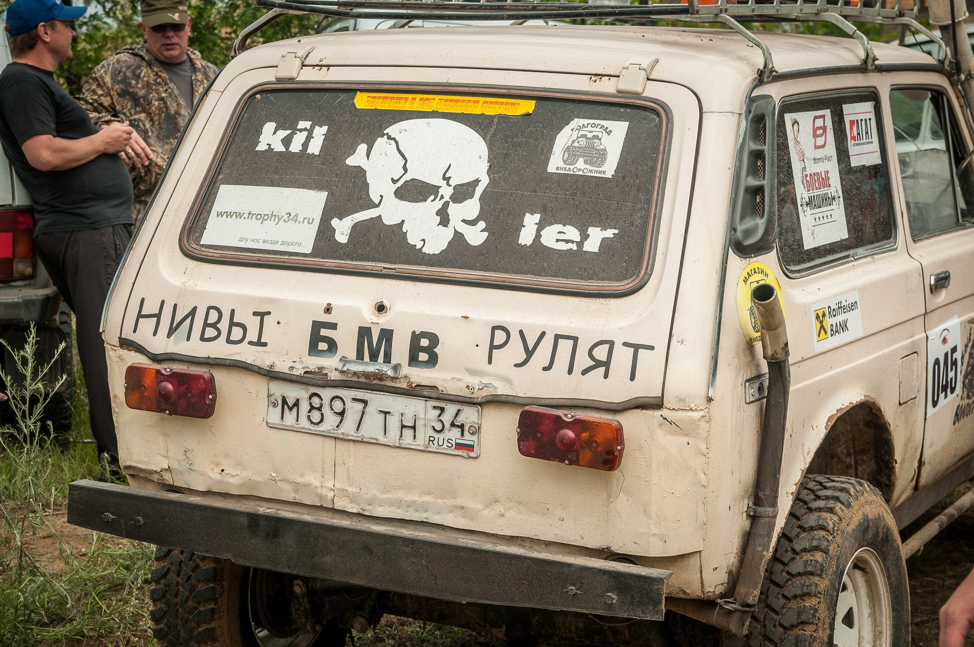 Бежевая Нива с надписью "Нивы рулят и черепом на заднем стекле