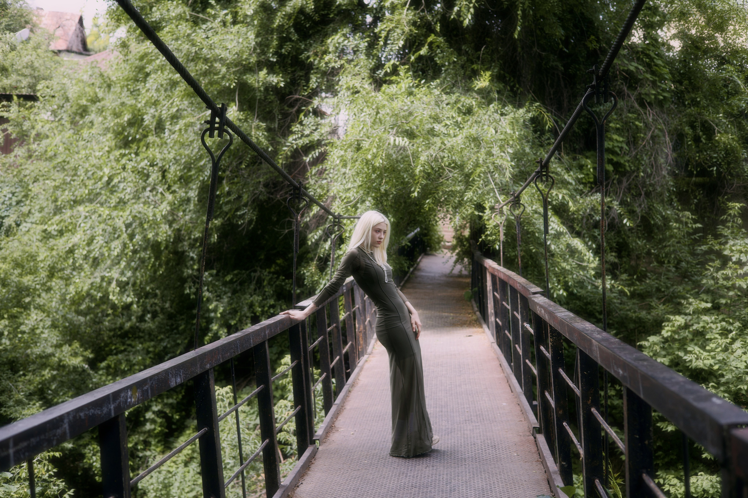 Девушка позирует посреди подвесного моста во время фотосессии