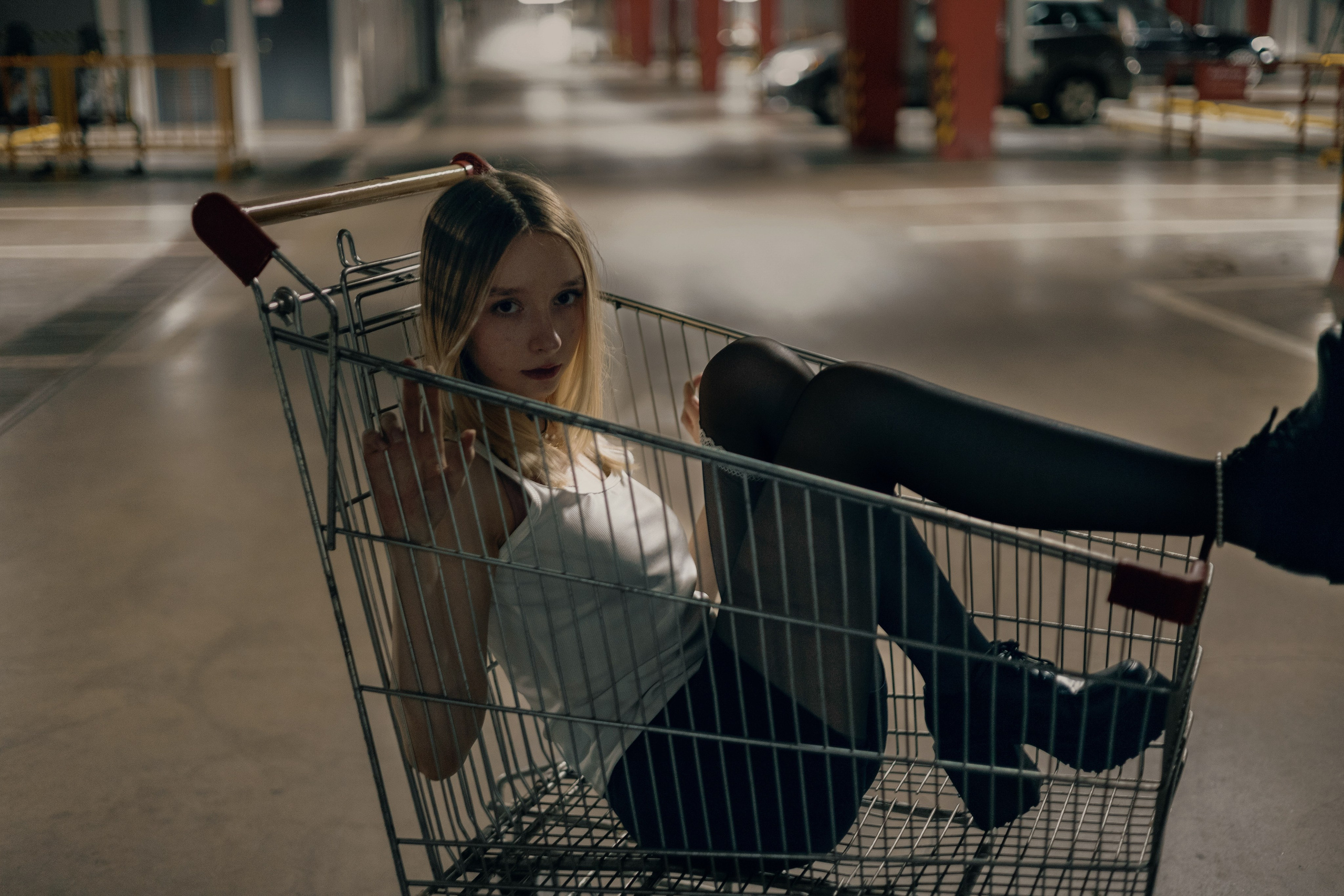 Урбан-фотосессия в стиле гранж — девушка сидит в тележке на парковке