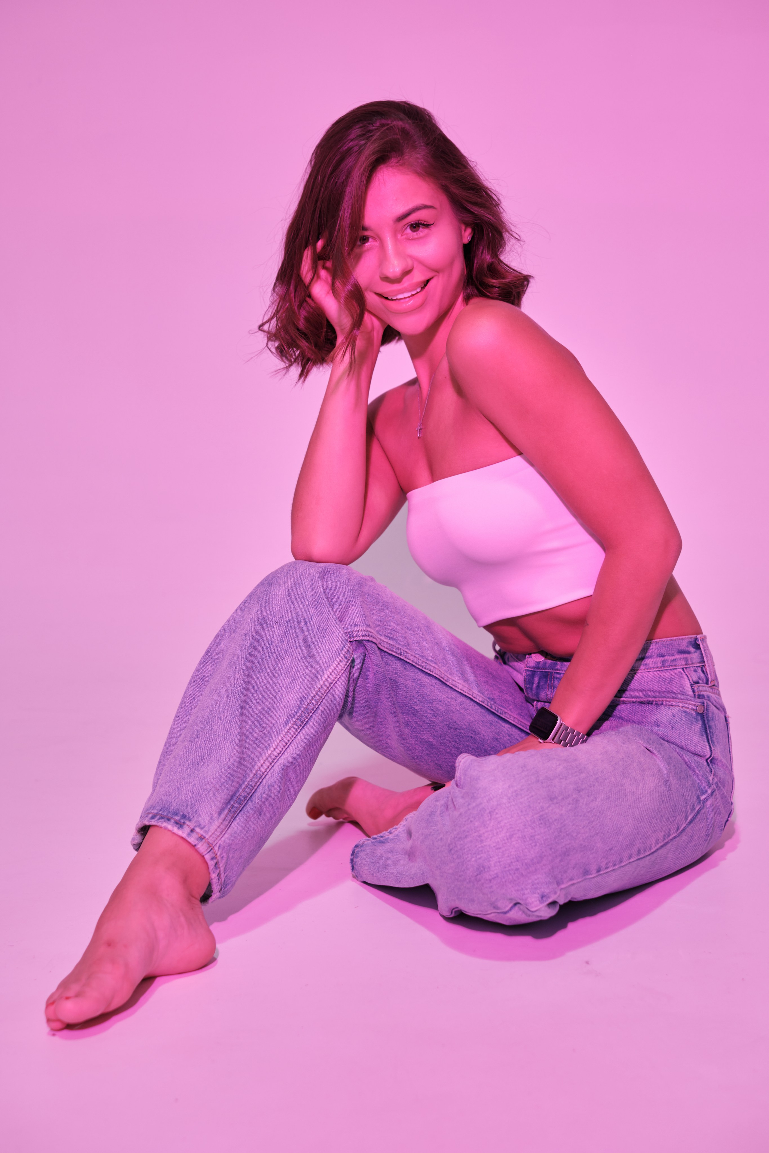 Сьемка в студии для модельного агентства, девушка в джинсах и белом топе, розовый свет