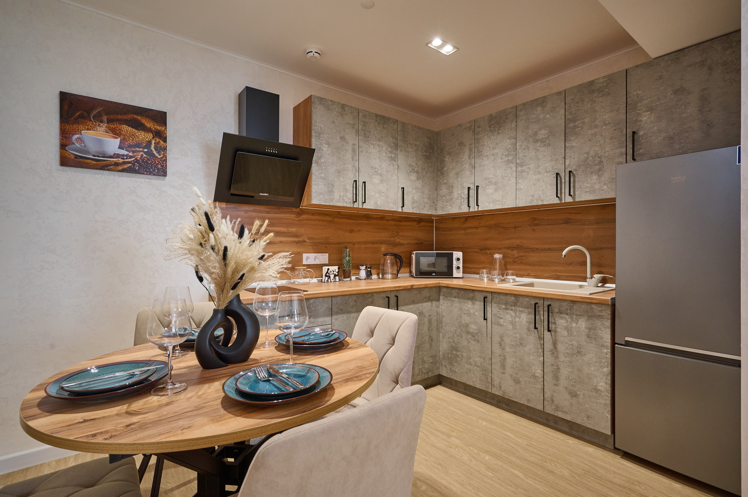 кухня серые оттенки серые полки и ящики серый холодильник раковина круглый деревянный стол стулья