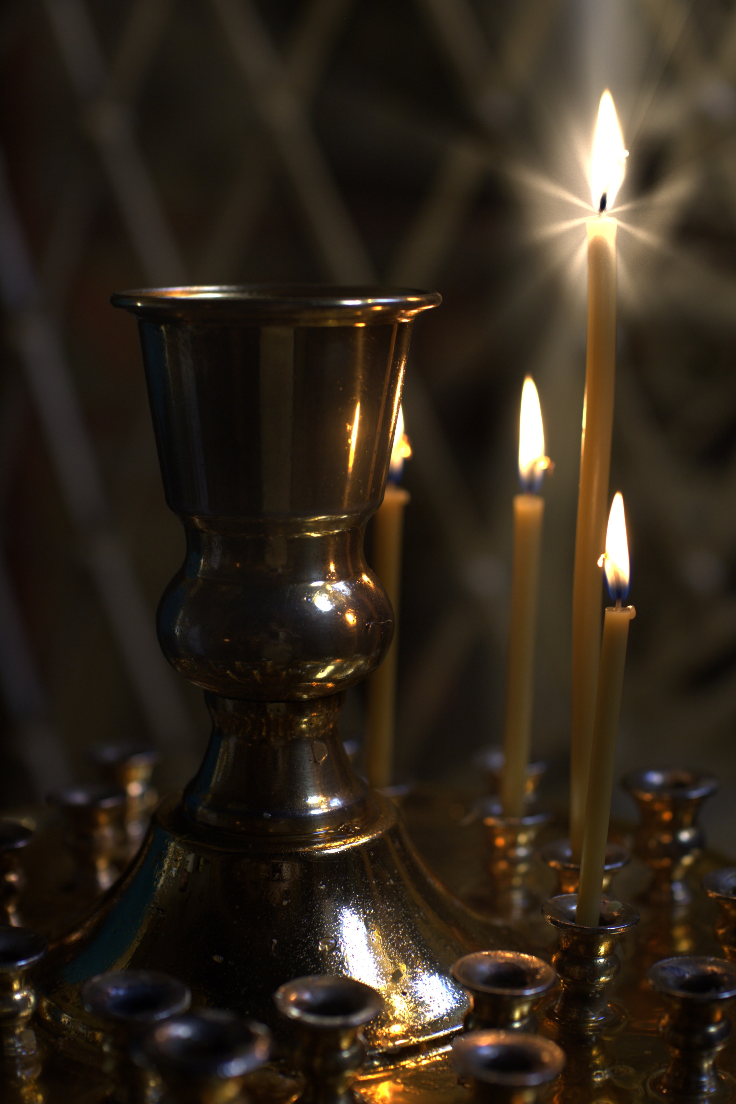 Горящие церковные свечи на латунном подсвечнике в храме во время крещения