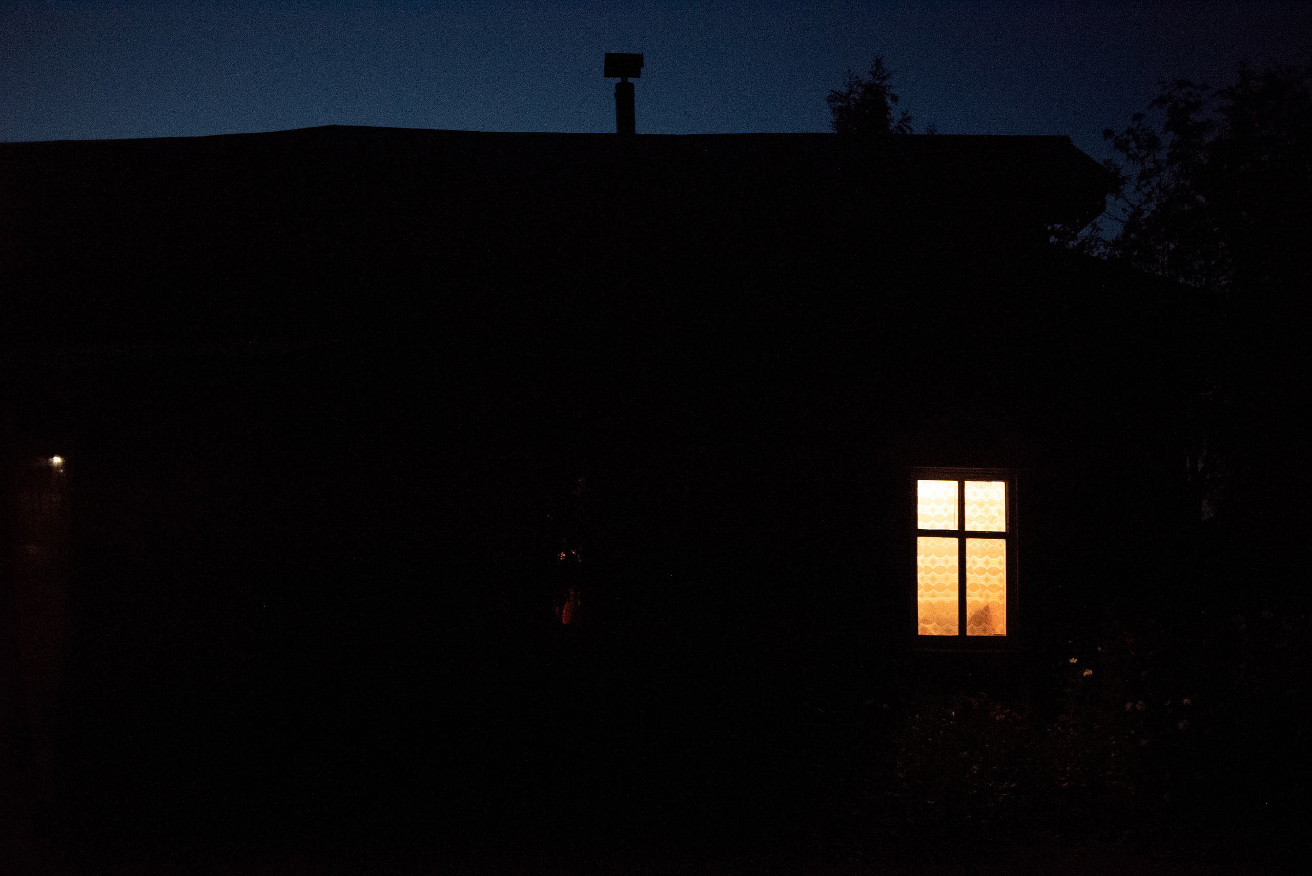 Деревенский дом ночью и свет в окне
