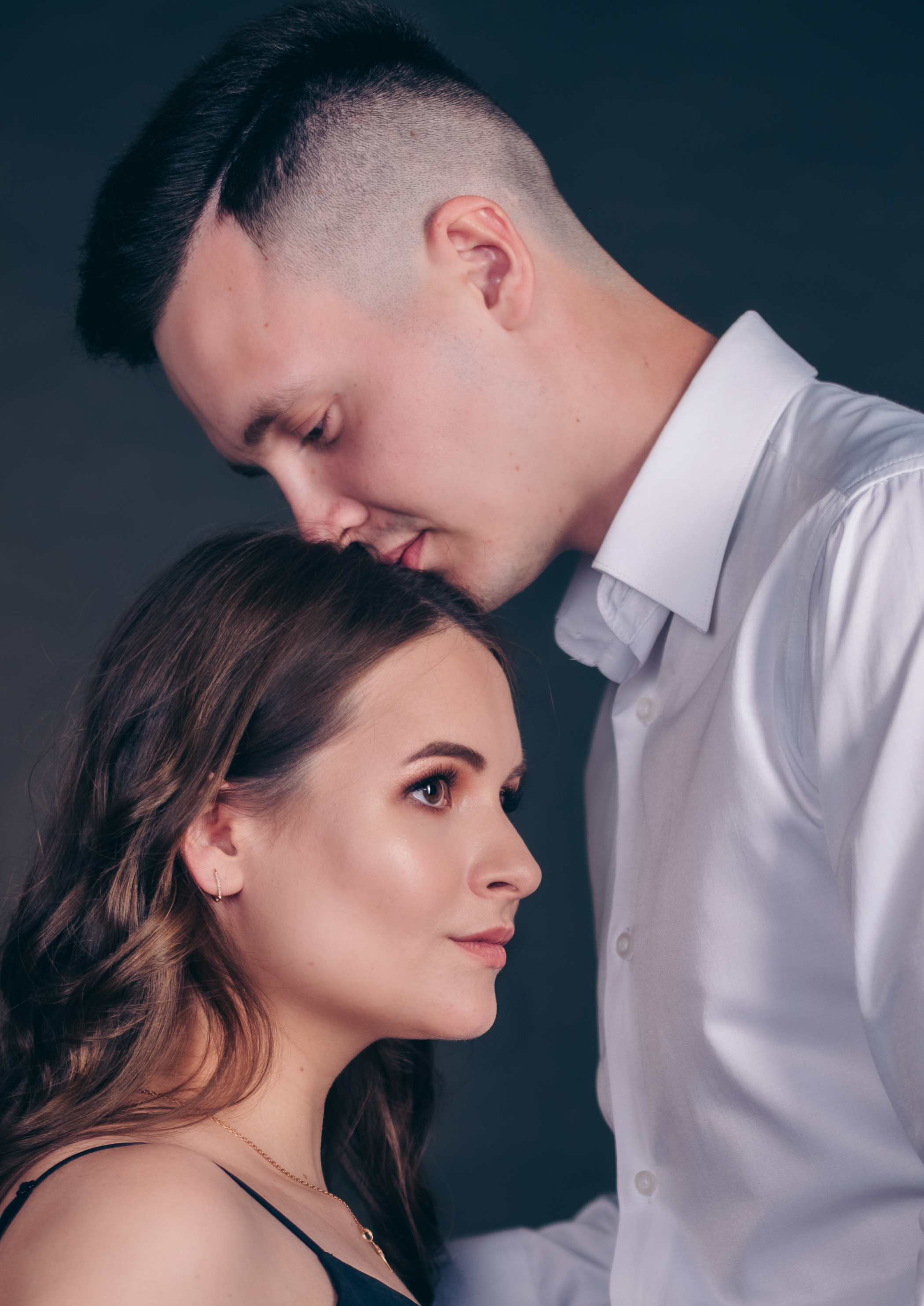 муж целуют жену в макушку крупным планом лица