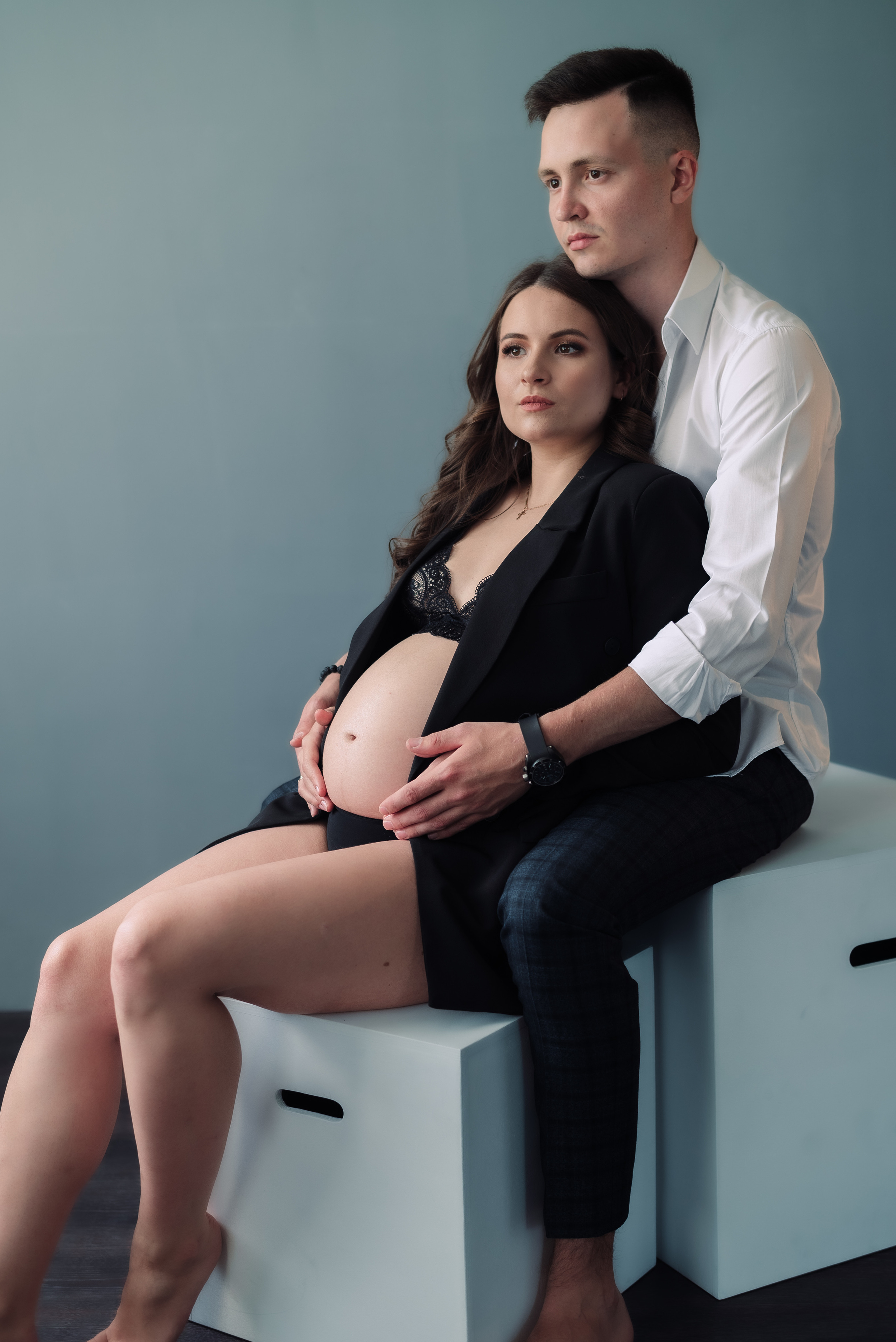 молодая пара сидит на кубах в фотостудии