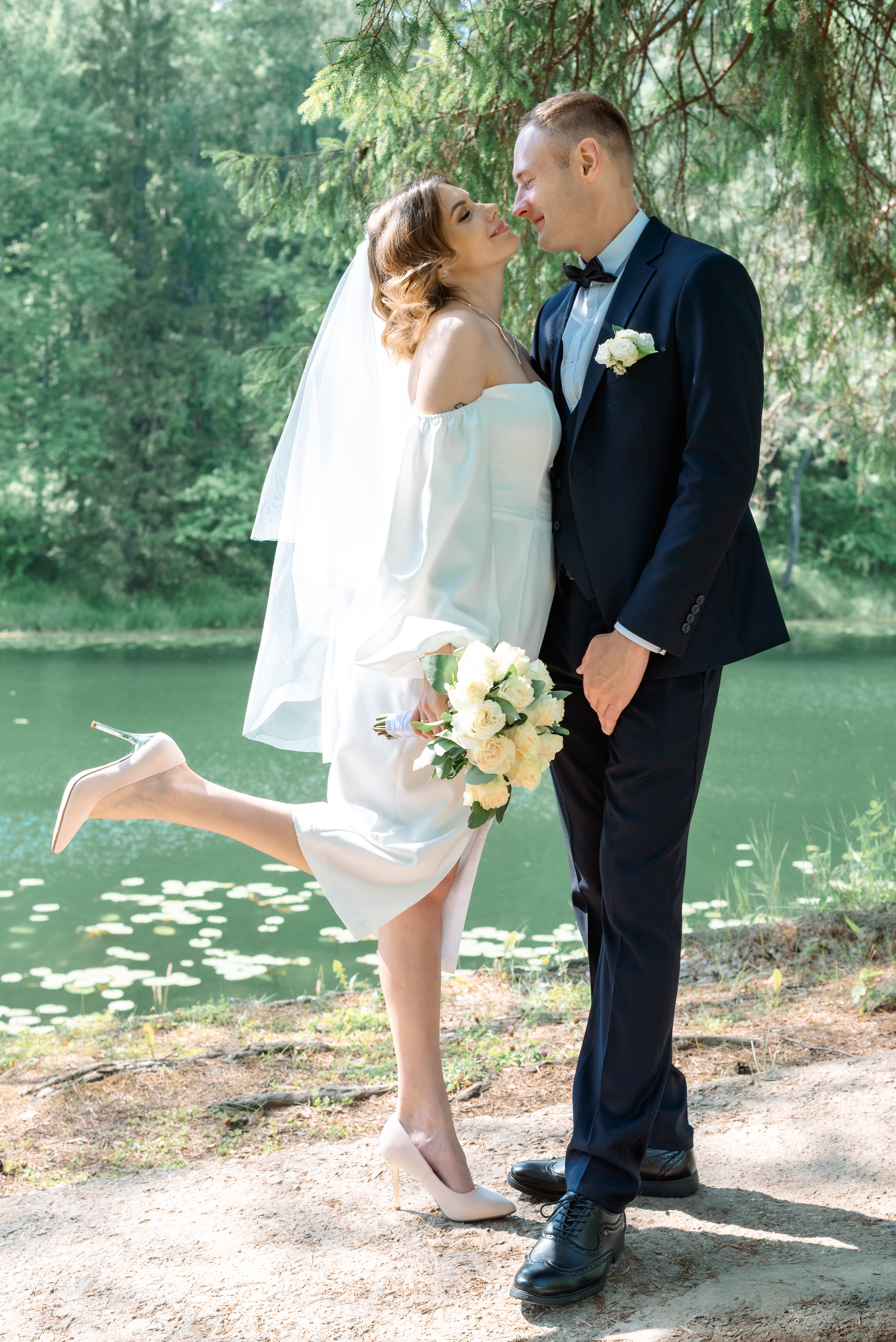жених и невеста на фоне озера стоят в полный рост