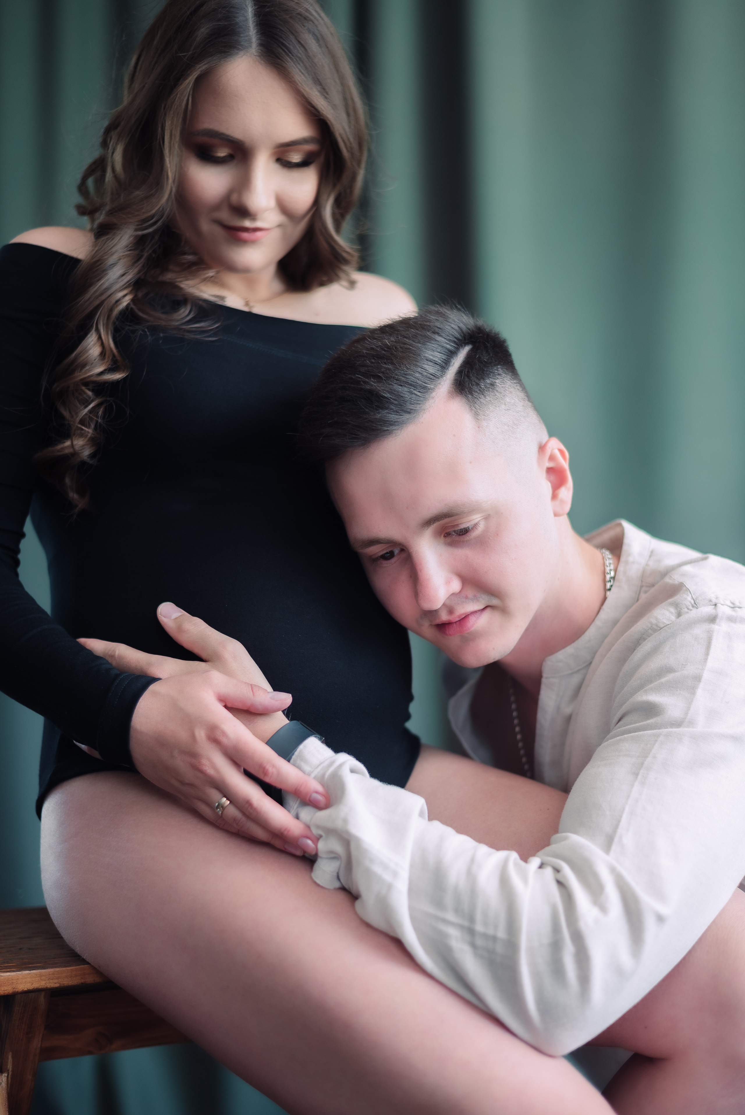 будущий папа прикладывает ухо к животу беременной жены