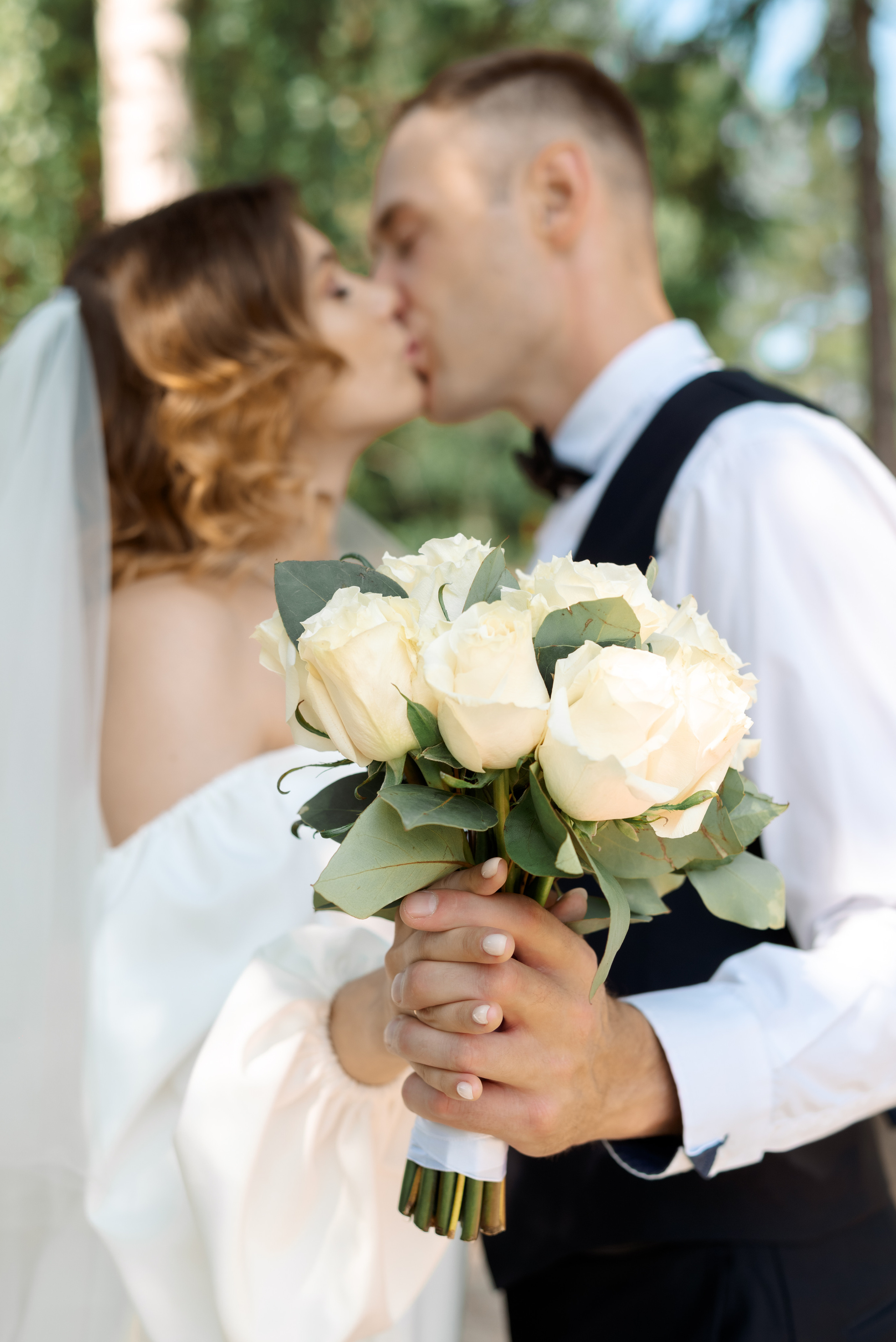 букет невесты в руках у молодой пары