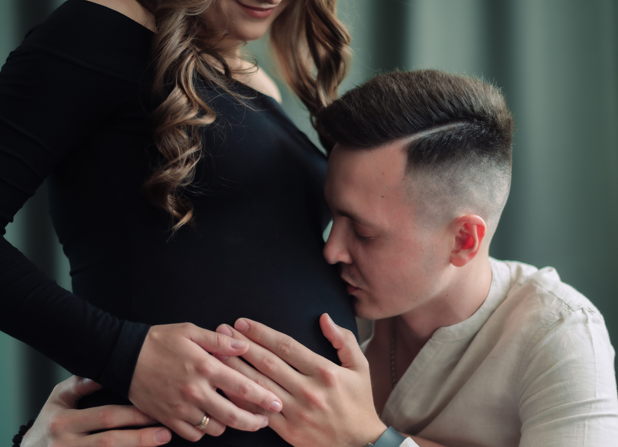 будущий папа целует живот беременной жены