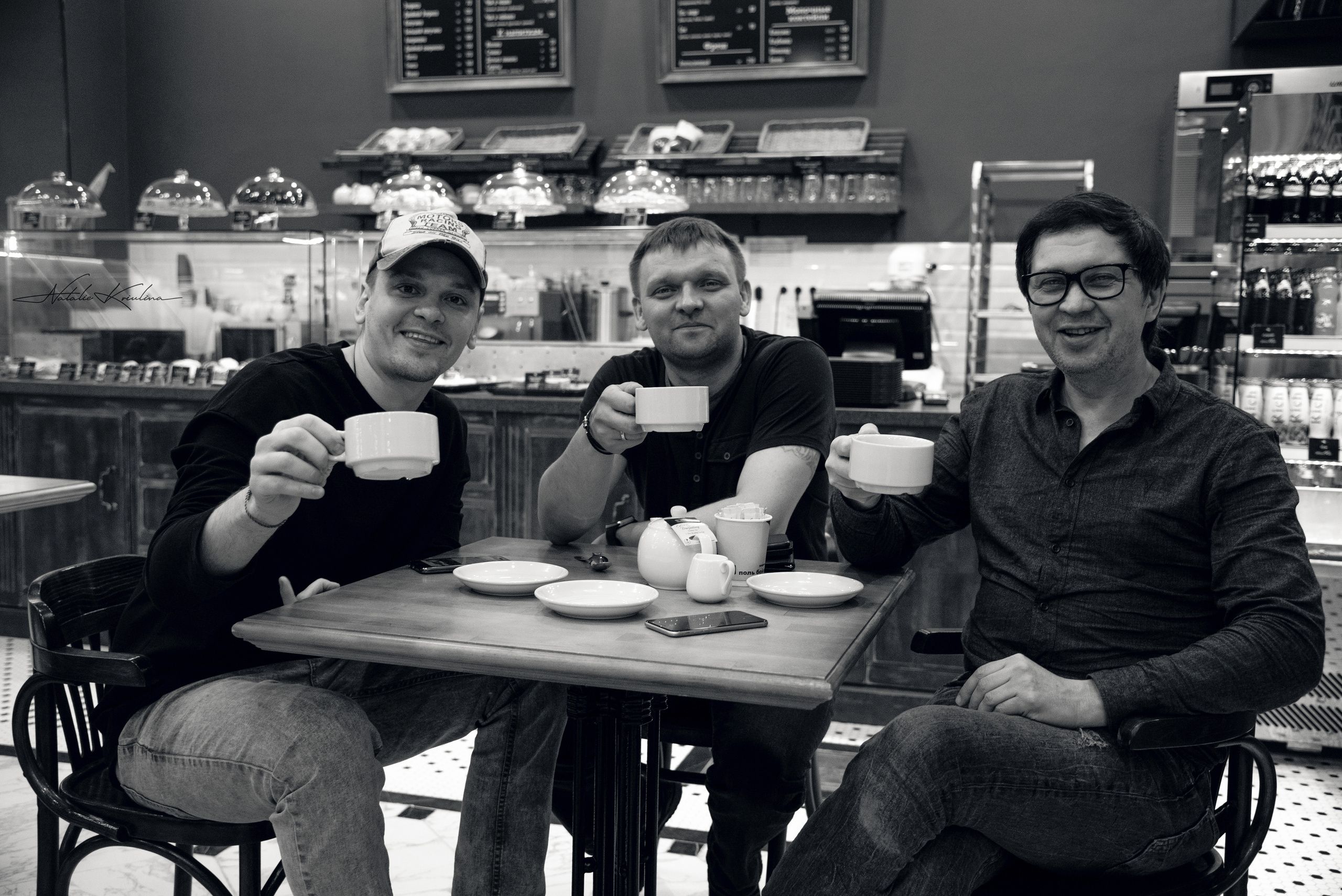 Мужчины за столом в кафе пьют чай