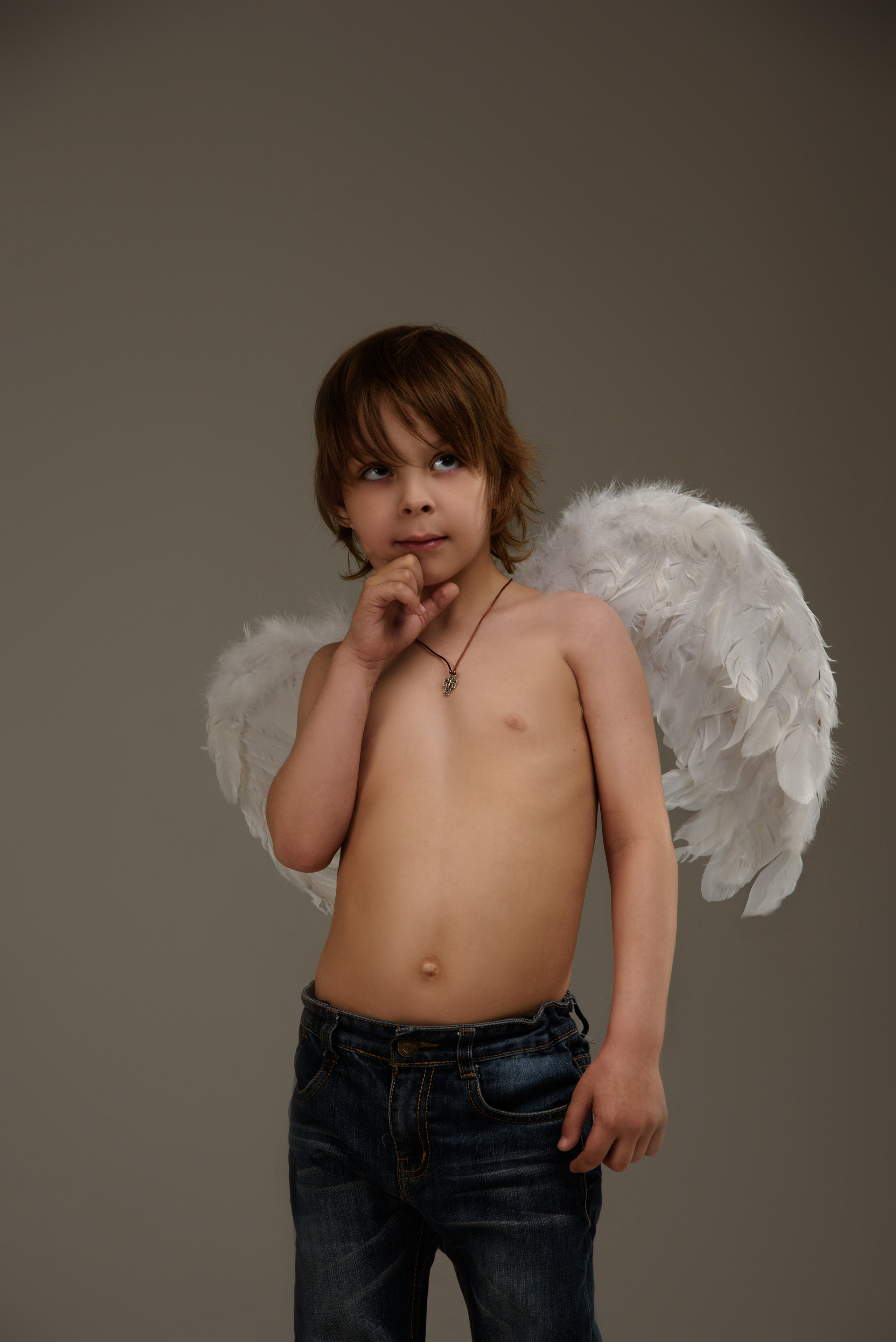 мальчик ангел задумчиво смотрит вперед