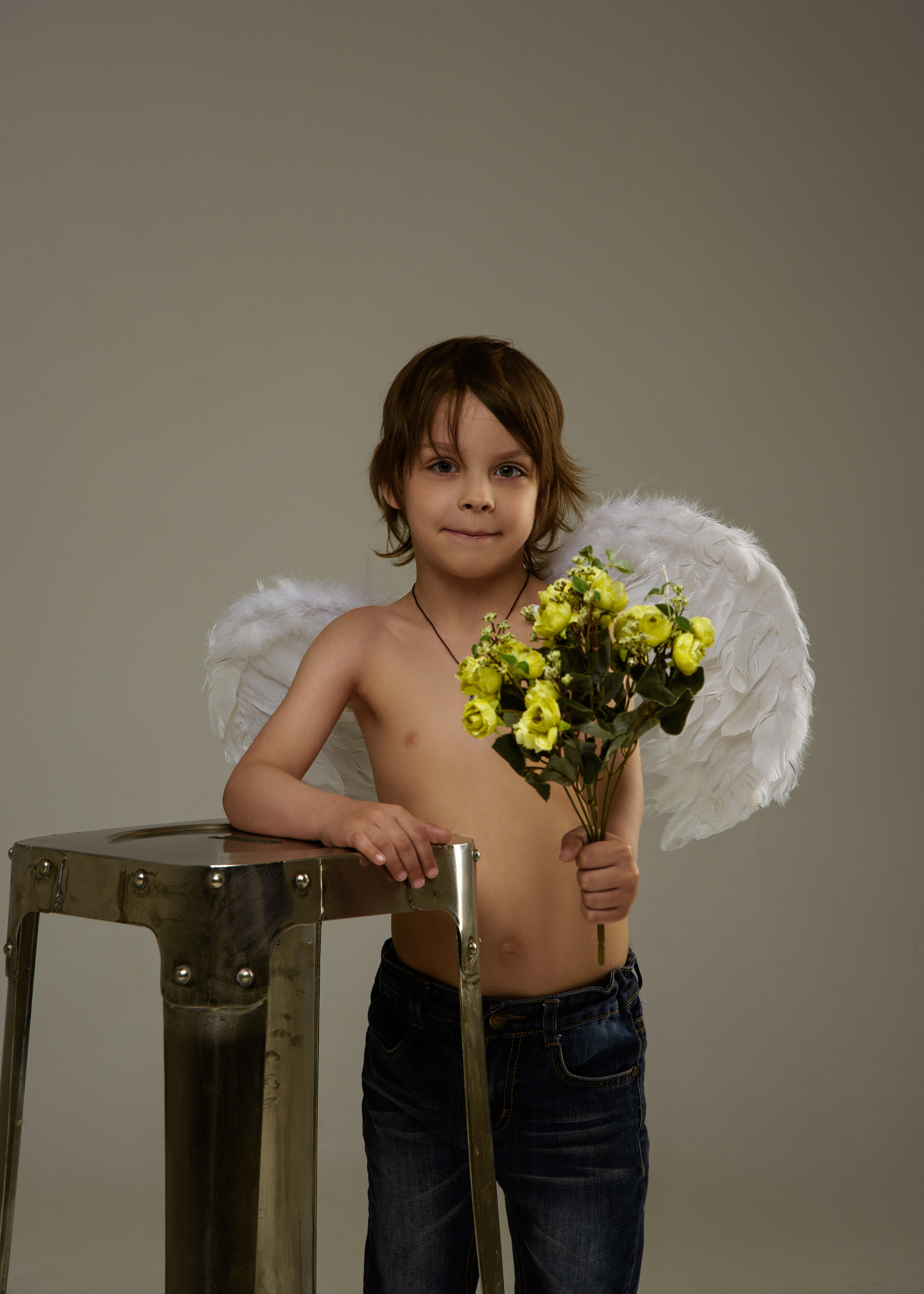 улыбающийся мальчик ангел с букетом цветов