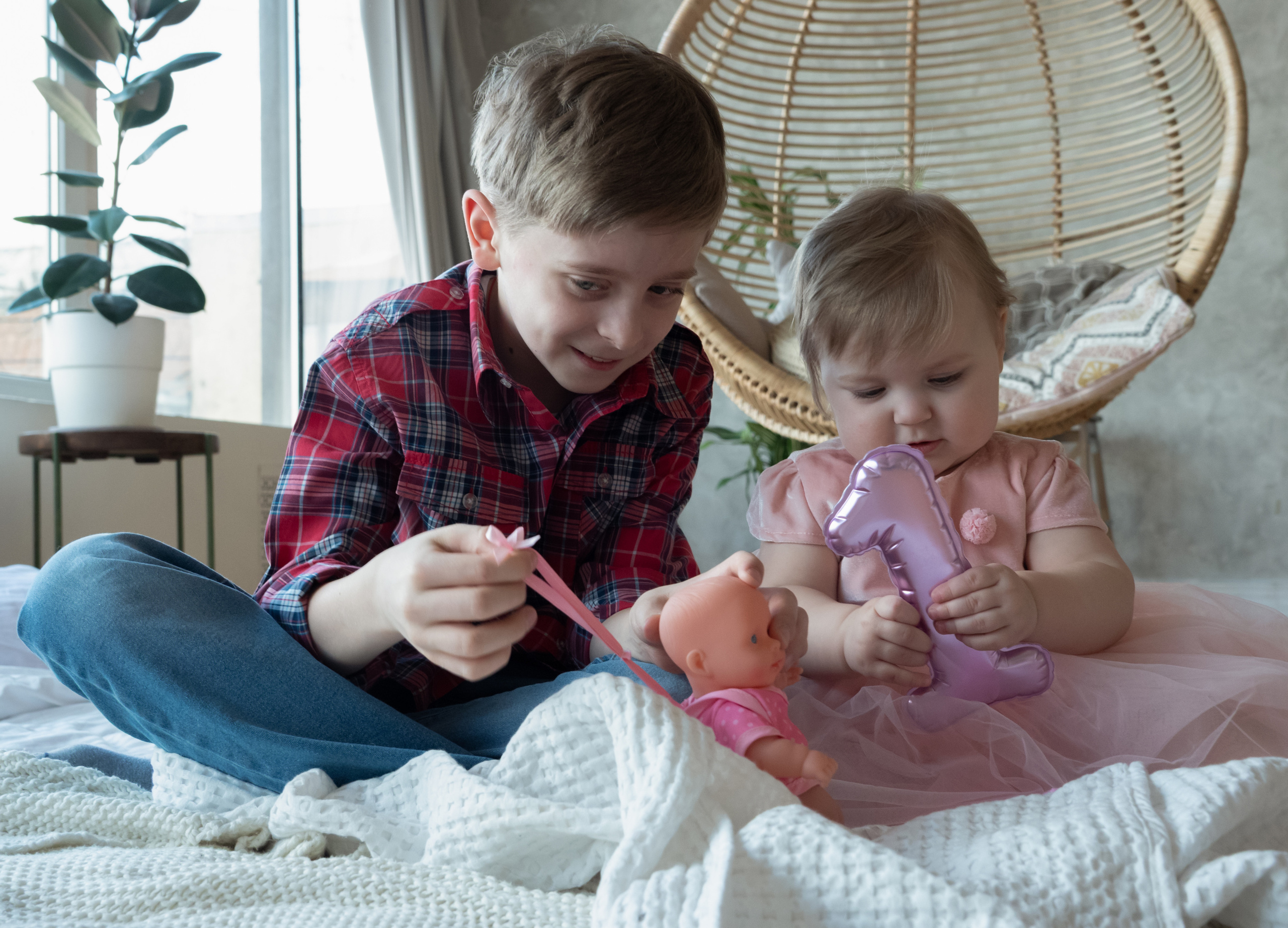 брат показывает маленькой сестре игрушки