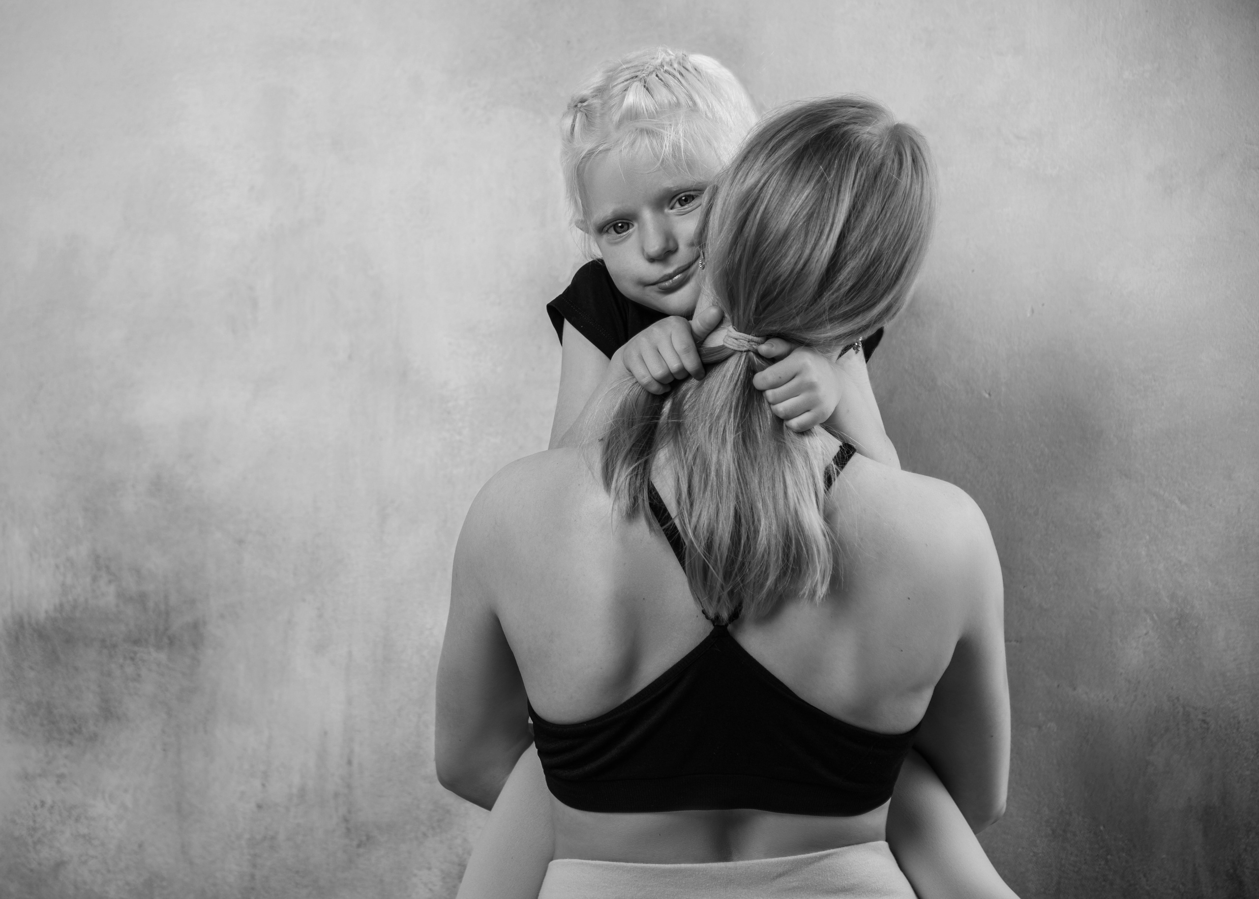 семейная фотосессия в студии на которой ребенок дочка нежно обнимает маму 