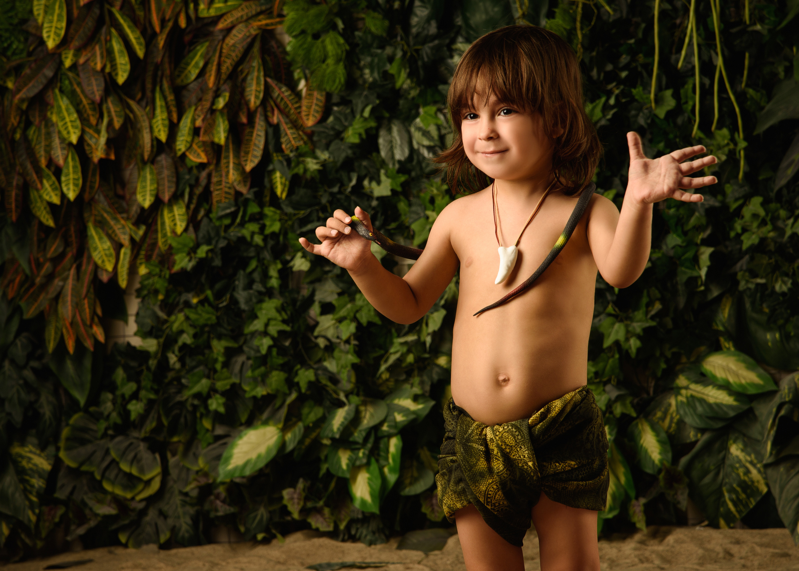 мальчик Маугли со змеей в руках разговаривает